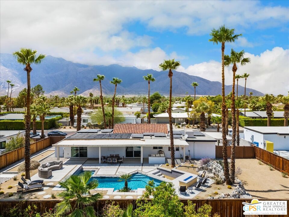 Resort living starts right at home in this alluring and upgraded 3-bedroom, 2-bath Palm Springs retreat. Tucked away on a quiet, well-manicured street, this home offers not only breathtaking mountain views, but also a RESORT-STYLE BACKYARD that's built to impress! Set on over a quarter acre of FEE SIMPLE LAND (you own it (NO land lease, NO HOA fees), the property is just minutes from downtown Palm Springs and Highway 111, offering both convenience and privacy. Step inside to find a thoughtful floor plan that separates the bedrooms from the main living and kitchen areas, ideal for both entertaining and relaxing. Vaulted ceilings in the living room add volume and natural light, while the remodeled kitchen shines with white shaker cabinets, quartz countertops, tile backsplash, and stainless steel appliances. The home features engineered wood floors, DOUBLE-PANE WINDOWS AND DOORS, and has been COMPLETELY REPLUMBED in 2022, including the main line to the street. A NEW ROOF (2021/22), 200-AMP electrical panel, OWNED SOLAR PANELS and a SOLAR HEATING SYSTEM for the pool offer energy efficiency and peace of mind. Outside is your own private oasis: an Alumawood patio cover opens to a sparkling custom pool with i-Aqualink pool control system, sunken swim-up bar with built-in fridge and ice stations, outdoor kitchen and BBQ areas, fire pit lounge (both BBQ and fire pit are hooked to natural gas), raised tanning decks, natural rock accents, and a bocce ball court with room for cornhole and outdoor gamesall framed by stunning mountain views. The home is ready for all your motorized toys with an Alumawood carport cover, and the flexible-use garage with mini-split A/C is perfect for a hobby room, hangout space, or bonus living area. This home is Airbnb-ready, and can be sold turnkey furnished (with a few exclusions), making it truly MOVE-IN READY. With only a 10 minute walk to Albertsons, Steel Gym, Starbucks, and Domino's, this property is more than just a place to live, it's YOUR Palm Springs dream! Don't sleep on it!