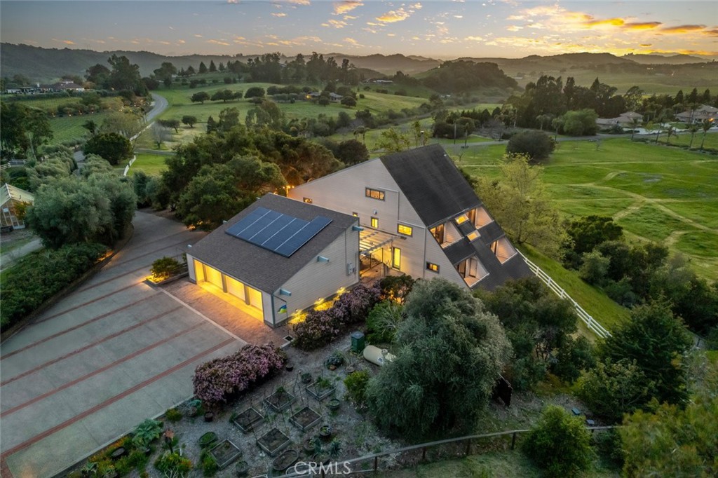 Private Edna Valley Retreat on 10 Usable Acres with Greenhouse, Small Horse Barn and Arena, Family Citrus Orchard, Greenhouse, Raised Beds Veg Garden & Panoramic Views. Discover the rare opportunity to own a gated 4-bedroom, 4-bathroom estate perched on a gentle hilltop in the heart of Edna Valley. Situated on 10 usable acres, this expansive property offers panoramic wraparound views from every room and a lifestyle rooted in nature, privacy, and versatility. The main residence is designed for both grand living and flexible multi-generational use. With private decks off of each level, soaring vaulted ceilings, white oak wood features throughout, and a thoughtfully designed chef’s kitchen with a butler’s pantry, this home blends rustic charm with modern comfort. Whether you’re entertaining guests or enjoying a quiet morning overlooking the rolling hills, you will relish the space and serenity that this property provides. A flexible floor-plan allows the home to be lived in as a spacious single residence or partitioned into three separate, self-contained living areas, each with its own private entry, full kitchen, bathroom, and outdoor space—perfect for extended family, guest quarters, or income potential. All three luxurious suites provide options and comfort. One crowns the top floor with its own private office, spa-like ensuite bath with soaking tub, and private decks off of both the office and bedroom. The second suite is on the main level, featuring its own deck, private entry, walk-in shower, and a cozy kitchenette with dining/lounge area—ideal for extended guests or independent living. The third suite also has a private entry, two bedrooms with decks off of each bedroom, full bathroom, kitchen, and a dining/lounge area for extended family or income potential. Outside, the property is rich with homestead features including a 3 stall horse barn with large turnouts, a large greenhouse for year-round gardening, an orchard containing a variety of citrus and stone fruit trees, and a chicken coop ready to supply fresh eggs. A 3-car garage provides ample space for vehicles, storage, or a workshop. Located just a short drive from both downtown San Luis Obispo and the Village of Arroyo Grande, this peaceful, private haven offers country living with close proximity to world-class dining, shopping, and wineries. Come experience the magic of 1505 Tiffany Ranch Road—where views, versatility, and lifestyle meet.