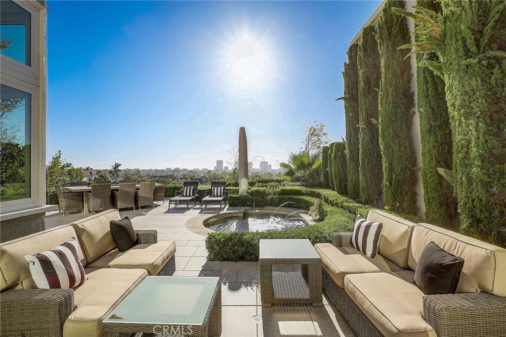 This stunning, fully-furnished Harbor Ridge estate is sure to impress with stunning ocean, Catalina, and city lights views. Perched above San Miguel Park, you'll love looking out over the grassy park to Fashion Island and out to the coastal horizon of Newport Beach. On a clear day, you'll marvel at the Catalina views from this spectacular hillside property. Entirely remodeled with top-of-the-line finishes, this is a designer's dream. Enter through a gated courtyard to a grand double door entry. On the first level you'll find the ground-level guest bedroom, full guest bath, laundry room, and direct access to the 2-car garage. Step down to the formal living room with a bar, beautiful beamed ceilings, and floor-to-ceiling windows. Glass french doors welcome you out to a private oasis. Relax in the spa enjoying the calming sound of the fountains or watch the incredible sunsets from the fire pit. The adjoining dining room also boasts incredible views and the family room too features high ceilings and french doors out to a private deck with a grill and more spectacular views. Situated just above the deck is a private turf lawn shaded by mature trees, exclusively for your enjoyment! The kitchen has all the counter and cabinet space you could need with a large island, gorgeous marble counters, high-end appliances, a breakfast nook with more breath-taking views, and a sliding door to the backyard so you can enjoy outdoor dining. Upstairs find a spacious loft for movie nights, 2 additional guest bedrooms, a full guest bath, and the primary ensuite with some of the best views in the home! The primary bath will surely take your breath away with a private balcony boasting panoramic views. Sip your coffee in the morning perched up on this patio. Enjoy the luxurious jetted tub, walk-in shower, dual sinks, and vanity area. You'll love the beautiful hardwood floors, recessed lighting, and designer touches throughout this home. Enjoy community amenities including 4 pools and spas as well as several tennis courts and a park just across the street with walking trail from lower Harbor Ridge to upper Harbor Ridge. Located just minutes from Pavilions and Gelson's, Newport Hills and Harbor View Shopping Centers, Rodger's Gardens, and some of the best shopping and dining in OC at Fashion Island and Corona del Mar, not to mention some of the best beaches in all of OC, this property is truly a dream come true!