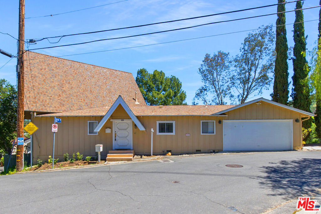 PLEASE NOTE: GARAGE IS EXCLUDED. There are two spots of off-street parking included. Charming storybook house with beautiful mountain views in peaceful Woodland Hills. Traditional post and beam construction w/ contemporary flair, character and charm. Light, bright, airy, with a split-level design and open floor plan. 4 BR/2 BA with hardwood floors & crown moldings. 2 beds up and 2 beds down. Updated kitchen has custom cabinets, granite counters, stainless appliances, recessed lighting and an island along with a KitchenAid triple-tier burner and convection oven. Dining room opens to spacious sunroom with high ceiling & nature views. Step down living room is warm and inviting with a decorative fireplace, and opens to a patio. Bathrooms have been updated w/ new vanities. Upstairs bedrooms and bathroom have vaulted ceilings and ceiling fans. Non-covered parking spots for two cars. Easy street parking with no street sweeping restriction. Other amenities include Double-glazed windows, USB-A & USB-C outlets in every room, Smart Ecobee Thermostat, Hillside views from master bedroom balcony, 24/7 professional security monitoring - RING, LG french door stainless steel refrigerator, Instant Hot on-demand filtered water, One 43" Smart FireTV, Dishwasher, garbage disposal, refrigerator, washer/dryer included. Great location, close to the 101 FWY, PCH, Topanga State Park hiking trails, Calabasas, Ventura Blvd, shops & restaurants! The Woodland Hills Country Club is only one mile away. 3.5 miles away, the affordable Calabasas Tennis & Swim Center offers semi-private access. Home is in the affluent area of Girard Tract neighborhood. *Available Mid-late June 2025*