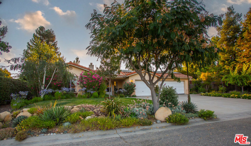 A feeling of deep warmth welcomes you to this expansive Central Coast Wine Country property in charming Los Alamos and all it has to offer. Covering nearly acre corner lot, bordering greenbelt that is literally a pine and cypress forest, the sense of place and privacy is remarkable and rare. The grounds are nothing short of your own private park, featuring countless mature trees including two apples, 1 each plum, pear, fig, lemon, lime and Thompson grapes; a waterfall and koi pond, planting beds with artichokes, leeks and asparagus, as well as discrete spots for the both bee keeping and chickens. The entire rear of the house is protected by a full length, covered patio. And then, there is the house with a flow that is a dream for entertaining, one space opening to the next, with most rooms giving onto the stunning gardens, patio and hot tub. All grounded by the richness of hardwood floors throughout. Bedrooms are discretely separated with the primary suite self-contained.The glorious cook's dream of a kitchen with rich, custom hardwood cabinetry, top quality appliances including a double wine cooler is bookended by the living/dining room with stunning stone gas fireplace and the large lounge/family room. The sum of it all, mindfully created for large scale entertaining or intimate dinners and quiet evenings watching the sunset views. There is a mood to be sure.Lots of room for discrete, off-street and gated parking or storage for your grownup toys, plus the oversized three car attached garage, part of which is currently in use as a second kitchen. Add an ADU and create a unique family compound.