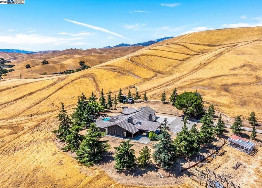 Behind a private gate, nearly 44 acres of scenic countryside surround this beautifully maintained single-level home at 8191 Highland Road. Offering approx. 3,000 sq ft, the 3-bed, 3-bath residence features spacious living areas, a remodeled kitchen, and serene views throughout. Enjoy the expansive terrace with pergola, pool, detached studio, and separate office loft—ideal for work or creative use. The land offers endless potential: pasture, vineyard, equestrian setup, or weekend escape. Additional highlights include a 2-car garage, carport, motor court, well, and multiple outbuildings. Located near shopping, freeway access, and the communities of Livermore, Pleasanton, Dublin, and Danville—yet far enough away to feel like your own private retreat.