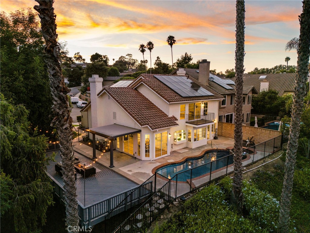 Perched above the canyons of Laguna Niguel with sweeping mountain & sunset views, 29312 Kensington Drive is a contemporary pool home that marries modern design with the best of California living. Set on one of the largest lots in the neighborhood, a unique pathway leads to a lower retreat shaded by mature trees, offering exceptional privacy seldom found in this community. This smart home allows nearly every function to be managed from your cellphone, granting unmatched convenience. Recently updated with stylish finishes & thoughtful upgrades, this turnkey 4-bed, 3-bath residence is move-in ready. A double-door entry & soaring ceilings welcome you into spacious, open living and dining rooms where natural light abounds & a sleek fireplace creates an inviting focal point. The kitchen is a showpiece with a large quartz waterfall island, custom cabinetry, designer tile, high-end stainless steel appliances & a charming atrium window, ideal for entertaining or everyday life. The adjacent family room offers a 2nd fireplace, wet bar, & sliding glass doors that seamlessly connect to the backyard patio, blending indoor comfort with outdoor living. A main floor bedroom & full bath provides ideal accommodations for guests or multigenerational living. Upstairs, the primary suite is a private sanctuary with vaulted ceilings, dual walk-in closets, romantic private balcony & spa-quality bath featuring a soaking tub, custom-tiled shower, & double vanities. Two additional bedrooms & an updated full bath complete the upper level. The three-car garage provides ample room for vehicles and storage. Highlights include wide baseboards, designer paint, recessed lighting, newer laminate flooring, plush carpet & an upgraded main electrical panel (accommodating all appliances—including simultaneous charging for two EVs—plus all household electricity needs at a monthly discounted rate). Latest Tesla batteries & solar ensure efficient energy use. The property is surrounded by varied, mature trees, enhancing both natural beauty & privacy. The outdoor spaces are perfect for relaxation & entertaining, with a spacious deck, multiple seating areas & a sparkling pool & spa, all enjoying uninterrupted mountain & canyon vistas. Ideally located near Ridge View and Clipper Cove Parks, Aliso & Wood Canyons Wilderness Park, shopping, dining, top schools, & SoCal’s iconic beaches, this home blends expansive outdoor living, modern design, & natural beauty for an exceptional lifestyle.