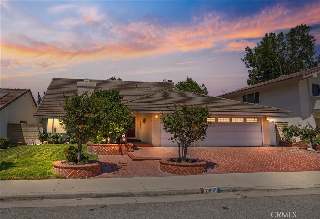 Welcome to this charming ready to move-in 5 bedroom, 3 bath, 3 car garage, turnkey home located near the Valencia paseos in the highly desirable Old Orchard 1 neighborhood. The custom brick hardscape leads to the double door entryway and continues to the tile foyer and expansive living room and formal dining area. The kitchen and family room area are beautifully framed by custom glass French doors. The kitchen boasts a long granite peninsula, granite countertops, lots of additional cabinet storage space as well as pass-through windows near the sink for indoor-outdoor entertaining in the park-like rear yard. The home's beautiful brick hardscape in the front, back and side yards with fully enclosed block walls adds to the home's security and privacy too. The large family room area includes a custom gas fireplace, full size windows along with sliding glass doors which bring in tons of natural light from the landscaped rear yard. Adjacent to the family room is the private oversized bedroom with sliding door access to the rear yard with its own private brick patio area and to the downstairs bathroom with a full size walk-in shower. Upstairs hosts 4 more bedrooms including the master suite with cedar lined closets, high ceilings and privacy throughout. The ensuite master bathroom is custom built with tile from floor to ceiling including a secluded jacuzzi tub and multiple shower head tub shower combination. The home is also equipped with double pane, energy efficient windows and sliders throughout, a smart thermostat system along with wall to wall cabinet storage in the 3+ car garage which includes a small bench/work area near the laundry. Accompanying this quiet and peaceful neighborhood is access to the paseos at the end of the cul-de-sac. The location is also ideal being close to shopping, restaurants, grocery stores and easy freeway access. The community itself also has many amenities such as parks, play areas, a pool, spa, club house, BBQ and picnic areas and is walking distance from the California Distinguished award winning Old Orchard School and to Hart High School with no Mello Roos and a low HOA, making this home ideal for anyone looking for a neighborhood with so much to offer.