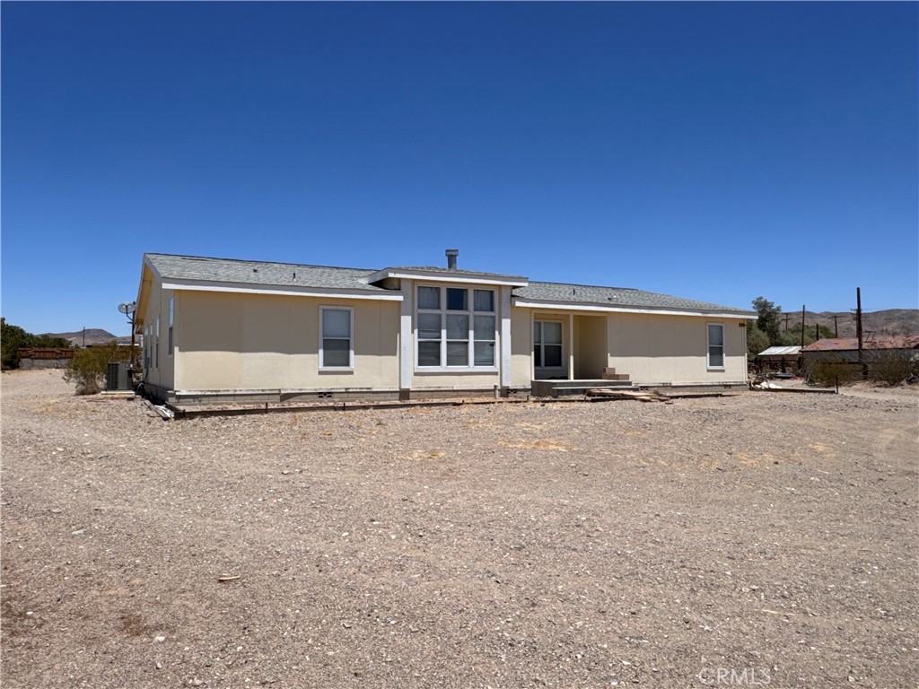 This expansive 5-acre property on the North side of Barstow, located on Old Highway 58, offers a unique opportunity with two mobile homes. The front home, built in 2007 and is on permanent foundation, it features 4 bedrooms and 2.5 baths across 2,568 sqft. Inside, you’ll find a spacious living room with a two-way fireplace, a family room, and a large kitchen with an island and ample cabinetry. The primary suite includes an office space, walk-in closet, and a bathroom with a soaking tub and separate shower. There’s also indoor laundry with a utility sink and a covered back patio. Just behind the main home sits a smaller single-wide mobile home with 2 bedrooms and 2 bathrooms in 720 sqft. Due to the condition, this property will not qualify for traditional financing. Bring your imagination—with some updates and repairs, this property has the potential to truly shine.