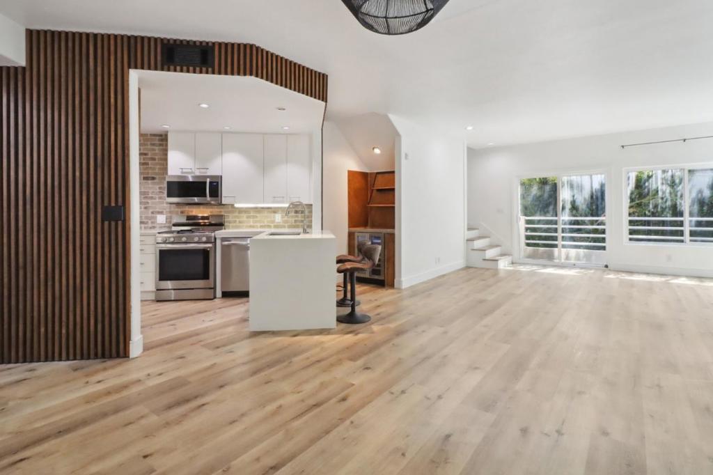 Nestled in the heart of Brentwood, this delightful multi-level corner unit townhome showcases a complete renovation, offering 1,525 square feet of modern elegance. Sunlight dances through the large windows and glass sliding doors, illuminating the vinyl flooring throughout. Moving seamlessly from the living area, the dining space transitions into a fully modernized gourmet kitchen, equipped with stainless steel appliances, quartz and butcher block countertops, a touch faucet, and custom cabinetry. Nearby, a bar area with a built-in wine fridge stands ready for entertaining. Downstairs, a versatile flex room awaits, perfect for accommodating guests or setting up a home office. Your private garage provides convenience with its electrical vehicle charging outlet and additional storage. Extra parking for guests is available and is on a first-come basis. Additional highlights include central AC, smart locks, a powder room for guests, and access to a community storage room. Plus, we extend a warm welcome to one furry companion, with a maximum weight limit of 20 pounds. It has an additional slot for assigned covered parking and proximity to Brentwood's vibrant amenities, including dining, shopping, and entertainment, along with easy access to UCLA and major highways.