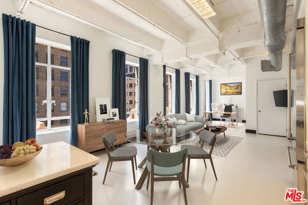 Soaring ceilings, streaming sunlight, and sweeping views define this stunning corner loft, available for lease in the historic 1929 Equitable Building at the legendary intersection of Hollywood and Vine. This 1-bedroom, 2-bath home features a spacious, open-concept design where natural light pours in from every angle. The expansive main living space flows effortlessly into the dining area and sleek white kitchen, ideal for hosting and entertaining. Fully equipped with premium stainless steel Viking appliances (including a dishwasher) and modern cabinetry, the kitchen is perfect for home cooks and entertainers alike. Just off the main space, you'll find a versatile bonus room ideal for a home office, home gym, artist's studio, or even a guest bedroom. Adjacent to this flexible area is a full bath with a deep soaking tub, offering spa-like comfort in the heart of the city. Tucked quietly beyond the kitchen is the serene primary suite, sunlit and generously sized, with an elegant ensuite bath featuring a walk-in shower and designer finishes. Additional amenities: all basic utilities are included, hookups for washer/dryer in unit, 24-hour doorman, 24-hour valet parking (one space is included), large storage space, access to a spectacular rooftop lounge complete with a fire pit, BBQ, dining area, and 360-degree views featuring the Hollywood sign, Capitol Records, Pantages Theatre, the Hollywood Hills, and more! Located just above The Birdcage and across the street from Katsuya, the W Hotel, and others, you are a short walk to Equinox, Barry's Bootcamp, and Trader Joe's, with coffee shops, restaurants, and nightlife in every direction. Stroll to Jemma, Lemon Grove, and Mother Wolf, or catch a show at the Pantages and pick up records at Amoeba Music just a block away. With the Metro station across the street, your commute to DTLA is effortless. Experience elevated urban living with iconic views, timeless character, and every luxury at your fingertips. This is Hollywood reimagined and waiting for you!