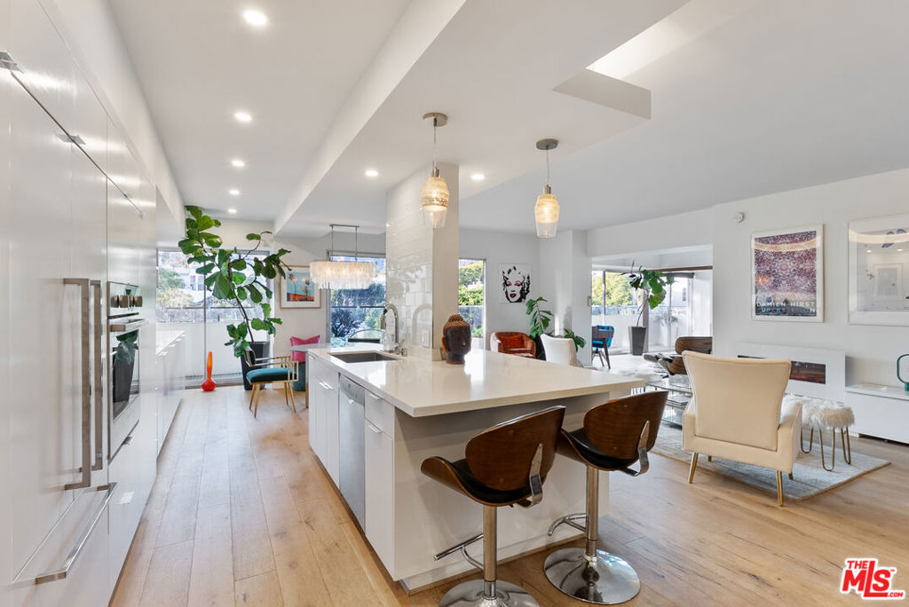 Welcome to 838 N Doheny Drive #505, an exquisite, light-filled residence located in one of West Hollywood's most coveted neighborhoods. This beautifully designed condo offers a seamless blend of sophistication and comfort, featuring an open-concept layout with floor-to-ceiling windows, rich wood flooring, and a sleek electric fireplace that anchors the living space. The modern kitchen is outfitted with premium stainless steel appliances, custom cabinetry, and a breakfast bar ideal for both entertaining and everyday living. The spacious primary suite serves as a private retreat, complete with a walk-in closet and a Spanish-inspired bath finished with elegant stone and designer fixtures. Additional highlights include in-unit laundry, secured parking, and access to a host of upscale amenities, including 24-hour concierge service, valet parking, and two beautiful pools, one on the rooftop with panoramic city views and another on the ground level. Almost all of the designer furnishings are included in the sale, making this a truly turnkey offering. And with its versatile layout, this space can even be reimagined as a two-bedroom residence if desired. Perfectly positioned just moments from West Hollywood's best restaurants, boutiques, and entertainment, 838 N Doheny Drive delivers a refined lifestyle in the heart of it all.