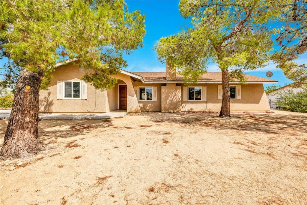 Welcome to A Million Stars Manor, a fully furnished desert retreat with four years of proven short-term rental success. Perfectly positioned on the main road to Joshua Tree National Park, which draws more than three million visitors annually, this 1,532 sq ft, 3-bedroom, 2-bath home sits on a desirable corner lot that combines privacy with high visibility. Inside, the thoughtful layout features a cozy sunken living room with a Saltillo-tiled fireplace, a bright sunroom for sunrise views, and an open kitchen and dining area with mountain and backyard vistas. The primary suite includes dual vanities and a walk-in shower, while the secondary bath offers an extended vanity and tub/shower combo. Tile and laminate flooring flow throughout the home, creating an easy-care, inviting space. Step outside to your private desert oasis: a sparkling in-ground saltwater pool, above-ground hot tub perfect for stargazing, multiple lounge areas, and mature desert landscaping. A detached, finished 2-car garage provides flexible use and ample parking. Additional highlights include 16 owned solar panels for low operating costs, strong branding with excellent rental performance, and an unbeatable location just minutes from the park entrance, restaurants, shops, and galleries. Offering both lifestyle and income potential, A Million Stars Manor is a rare Joshua Tree opportunity, a peaceful desert haven that also delivers proven profitability.