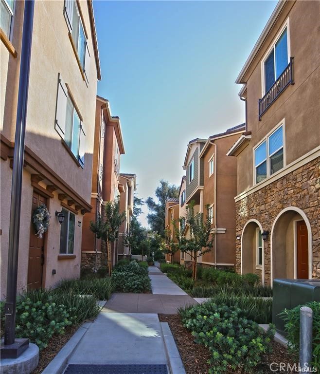 Newly built in 2018, this detached tri-level townhouse is situated in the desirable, gated community of The Grove in North Pomona. The intelligently designed floor plan offers 3 bedrooms, 2 full bathrooms, and 2 powder rooms. The entry level features a versatile open loft ideal as an office or playroom, a convenient powder room, and direct access to a private side yard through a sliding glass door. The second level presents a spacious great room combined with a dining area and a balcony, along with a well-appointed kitchen that includes plentiful cabinetry, granite countertops, a pantry, and a generous center island for casual dining. The upper level hosts the primary suite and two additional bedrooms serviced by a full bathroom. The primary suite includes a large walk-in closet and an en-suite bathroom with dual sinks and quartz countertops. This energy-efficient home is equipped with dual-pane windows, a tankless water heater, and water-saving plumbing fixtures. A 2-car attached garage provides direct access to the interior. Community amenities feature a playground and a BBQ picnic area. The Grove offers excellent proximity to the Claremont Colleges, Claremont Village, Old Town La Verne, and easy access to Metrolink and the 210 and 10 freeways. Truly move-in ready.