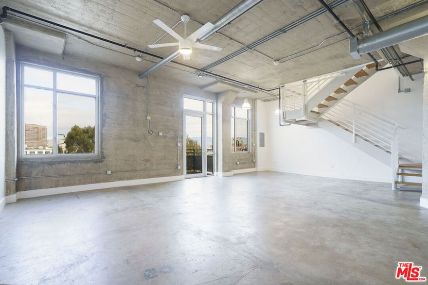 Step into an iconic two-story live/work loft at Beacon Lofts, where 1,910 square feet of dramatic concrete architecture meets sweeping north-facing views of Downtown LA and the mountains beyond. Located on the penthouse level (5th and 6th floors) of a converted 1920s warehouse, this rare 2-bedroom, 2-bath residence delivers scale, light, and versatility that few DTLA lofts can match. Designed for both inspiration and functionality, the open-concept layout features soaring ceilings, expansive windows, and a true loft aesthetic perfect for living, creating, entertaining, or running a business. Storage is abundant throughout, offering a level of practicality rarely found in industrial loft living. The crown jewel is the top-floor private patio a generous outdoor escape with majestic city and mountain views, ideal for hosting unforgettable gatherings, working under the sky, or simply enjoying quiet moments above the city. A private balcony on the lower level adds another layer of indoor-outdoor living and flexibility. Zoned live/work, this space is equally suited as a sophisticated home, creative studio, or professional workspace, creating an inviting atmosphere that adapts to your lifestyle. Set in the heart of the Arts District, you're steps from world-class dining and coffee: Bestia, Bavel, Girl & the Goat, Verve, Blue Bottle, and Urth Caffe; and directly across the street from the highly anticipated 4th & Central redevelopment, positioning you at the forefront of one of DTLA's most exciting transformations. Located on the border of Little Tokyo, the cultural energy, walkability, and long-term upside are unmatched. This is more than a loft it's space, scale, views, and opportunity, all wrapped into one unforgettable Arts District address. 3D virtual tour: https://my.matterport.com/show/?m=njk8acwb3NB