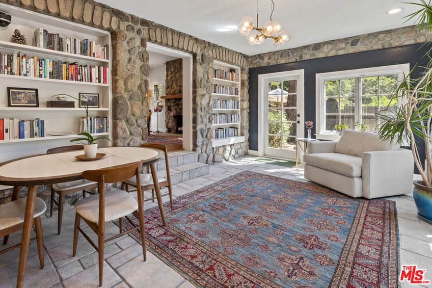 Elevated above the street and set back for maximum privacy, this exceptional residence offers a serene retreat on an expansive 8,871 sq. ft. lot. This beautifully updated 1932 stone house combines a rare blend of original details and modern updates providing ultimate comfort with direct access to the natural beauty of the Verdugo Mountains.  Behind its gated entry, you step into the fully enclosed grounds where you'll discover a spacious flat yard and multiple outdoor living spaces, including a covered dining area perfect for entertaining or relaxing in total seclusion. A private rear gate opens onto a trail providing effortless access to miles of hiking and recreation. Inside, the home retains its original character while thoughtfully incorporating high-end updates.  Upstairs the remodeled primary suite is a luxurious sanctuary, featuring vaulted ceilings, high quality Marvin Integrity windows, mountain views, a beautifully updated bathroom with Cle tile, a walk-in closet, ceiling fan, remote-controlled blinds, and its own dedicated HVAC zone for personalized comfort. On the main floor the updated kitchen offers extensive, recently redone cabinets, stainless appliances and a built-in pantry cleverly tucked away beneath the staircase. The kitchen connects to a stunning sundrenched dining room with built-in shelves and two walls of windows and doors to the outside, creating a seamless flow between indoor and outdoor living. The spacious living room features a dramatic floor-to-ceiling stone fireplace and stained-glass windows. At the far end of the house the generous secondary bedroom with walk-in closet connects to a den with built-in shelves and another full bathroom allowing it to easily function as a second primary suite.  A detached 400 sq ft studio with half bath offers infinite possibilities  whether as a creative space, home office, guest quarters, gym or an easily convertible ADU. The studio features new hardwood flooring, a separate HVAC system, tankless water heater and attic storage. The oversized two-car garage has ample storage and 220v power for EV charging.  Other recent upgrades include new roofs and gutters, and a new all-electric HVAC system. This magical property can feel like a world of its own but is just minutes from all the restaurants and shopping of downtown Burbank and a short 15-minute commute to major studios and much of the entertainment industry.  The property offers access to Burbank's top-rated school district and benefits from utility rates less than half of LADWP's.  Don't miss this rare opportunity to join the historical Country Club neighborhood, one of Burbank's most desirable settings.