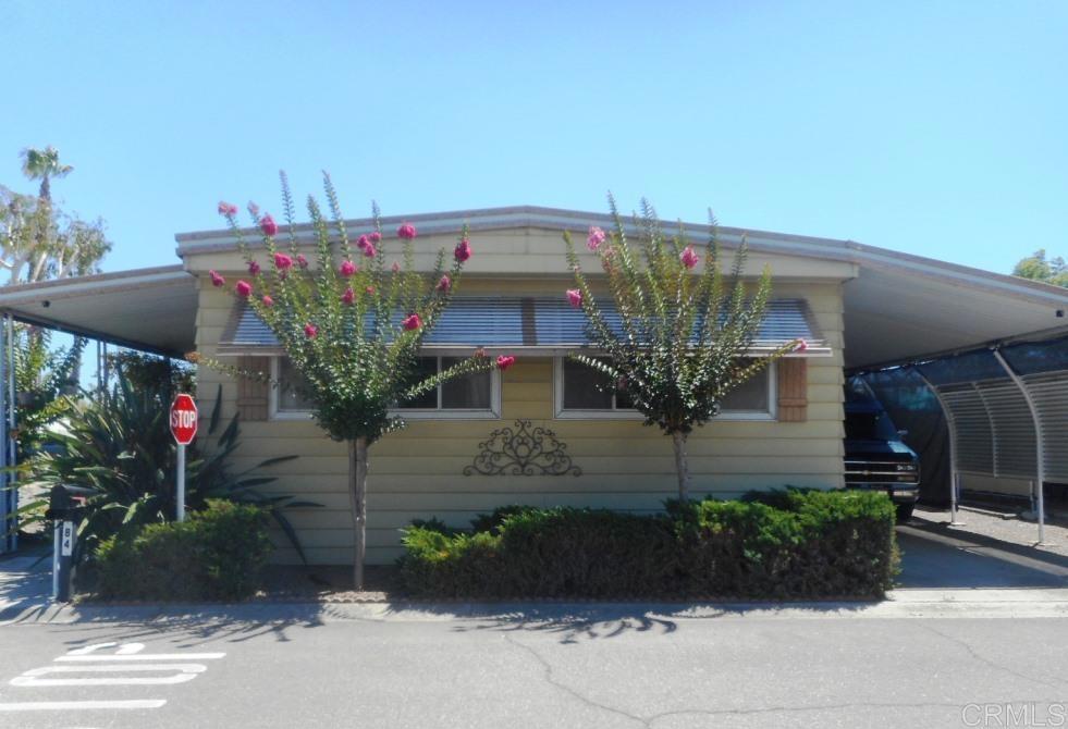 This larger mobile home offers comfort and convenience in a welcoming 55+ community. The home features a painted interior, wood laminate flooring, and an updated kitchen with modern cabinets. All appliances, including washer and dryer, are included. The bright living room has north-facing windows for natural light, while the separate laundry area includes extra closet storage and a solar tube for added brightness. The main bathroom is accessible from both the den and second bedroom, with a step-in shower and dual medicine cabinets. The spacious primary suite is painted in soothing decorator tones and includes a private dressing area surrounded by closets. The primary bathroom features a handicap-friendly step-in shower accented with glass tile. Outdoors, you’ll enjoy an expansive front porch—perfect for morning coffee or evening relaxation—as well as a handicap-friendly electric lift. The home sits on a corner lot with views of nearby mountains and hills. Community amenities include a heated pool, spa, shuffleboard, clubhouse with kitchen, library, and pool room. Conveniently located across from grocery stores, restaurants, banks, and a pharmacy, with a bus stop right outside the park. Low space rent of $635/month to new buyer.