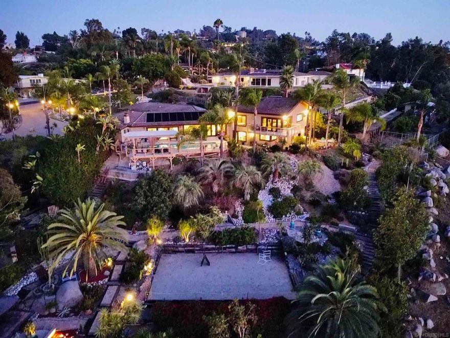 Nestled within the welcoming embrace of impressive gates, this exclusive neighborhood at the base of Mt. Helix presents a true masterpiece of luxury living. Captivating mountain vistas and sparkling city lights dance into view from nearly every corner of this property, a true entertainer's paradise. The residence unfolds with an inviting pool and spa, an expansive kitchen featuring a central island cooktop and an oversize eat-at counter, all seamlessly connected to a family room with a wet bar and a BBQ patio. Spanning over 5,083 square feet, the generous floor plan accommodates five bedrooms, four bathrooms, an office or playroom, and an expansive master suite with a fireplace, Jacuzzi tub, and a shower built for two, complemented by separate his and hers walk-in closets.  Nestled within the welcoming embrace of impressive gates, this exclusive neighborhood at the base of Mt. Helix presents a true masterpiece of luxury living. Captivating mountain vistas and sparkling city lights dance into view from nearly every corner of this property, a true entertainer's paradise. The residence unfolds with an inviting pool and spa, an expansive kitchen featuring a central island cooktop and an oversize eat-at counter, all seamlessly connected to a family room with a wet bar and a BBQ patio. Spanning over 5,083 square feet, the generous floor plan accommodates five bedrooms, four bathrooms, an office or playroom, and an expansive master suite with a fireplace, Jacuzzi tub, and a shower built for two, complemented by separate his and hers walk-in closets. The sprawling oasis of over an acre is adorned with beautiful palm and fruit trees, creating a tranquil and private haven. Noteworthy upgrades include a recently renovated concrete spa replaced in the primary bathroom with a modern jet tub and in-line heating system, all exterior doors and windows replaced with a lifetime warranty, stucco renovation treated with coolwall fire retardant, water, and insect resistance, and the addition of photovoltaic energy collection cells, owned with three arrays. The pool and deck have also been updated with solar heating, a new pump and piping, pool deck with boardwalk composite decking, and the addition of an in-ground spa and spillway, complemented by a dolphin fountain beside the pool. The professionally landscaped grounds are a work of art, showcasing lush lawns and gardens, rock walls, steps, and sidewalks, two golf cages, multiple sitting areas, two gazebos, a sand badminton court, large cactus and succulent beds, along with expansive plantings, rock falls, dry creek beds, and terraced front and side yards. Notably, the property has been featured twice in the GMIA art and garden tour. Don't miss this rare opportunity to own a home that harmoniously blends luxury, comfort, and breathtaking views in a coveted neighborhood. Schedule a private viewing today and experience the lifestyle you've been dreaming of.