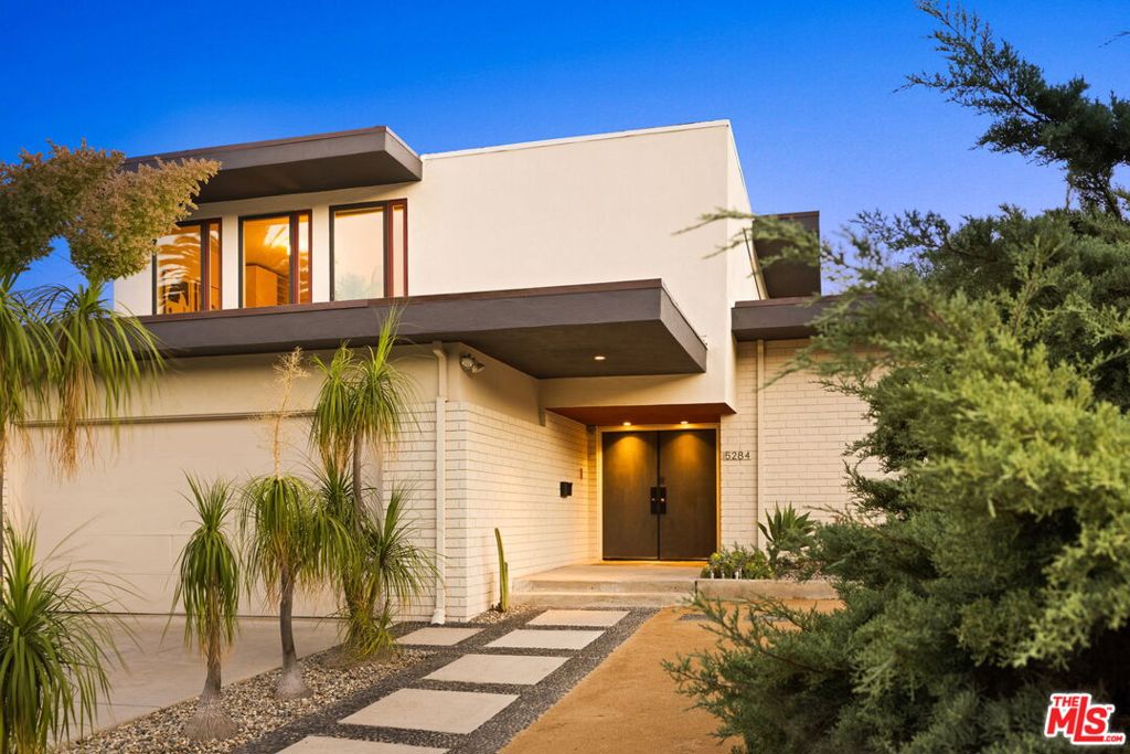 Built in 1964 and thoughtfully reimagined, this 5-bedroom, 4.5-bath, 3,827-square-foot home offers refined design and a livable scale. From the moment you step into the light-filled atrium, you know you're in a special space. Vertical wood screens soar nearly 20 feet high, filtering light and adding warmth and rhythm to the architecture. This striking feature anchors the entry and sets the tone for the home's rich material palette and open layout. The living room is expansive, with glass sliding doors that open to the backyard and city views. A sleek fireplace adds balance to the room's scale, while wool carpeting softens the space and invites conversation. The layout flows effortlessly into the dining room, atrium, and kitchen, making the most of the home's L-shaped footprint. The kitchen was designed for serious cooking and effortless hosting. Custom cabinetry provides ample storage, including a pantry wall, while warm wood finishes bring natural texture. The space includes bench seating for a full-sized table, bar seating, and wide counters that make both prep and entertaining easy. The dining room offers flexibility, large enough to double as a den or family room, and opens to the backyard. Right outside, a putting green and large dining patio overlook the skyline. The indoor-outdoor connection is seamless, with sliding glass doors in every room on the first level. The expansive downstairs primary suite is a retreat in itself with direct access to the patio, a large walk-in closet, and a luxurious ensuite bath with soaking tub, double vanity, and walk-in shower. Upstairs, a second primary suite offers privacy for guests or family, complete with a walk-in closet and full bath. Two additional large bedrooms share a bathroom with a double vanity, while a fourth bedroom with its own bath is ideal for a home office. The upstairs den offers an inviting space to unwind or work. Floors throughout the first level are newly refinished antique oak. Upstairs and in the living room, high-quality low-pile wool carpet adds softness and quiet. Located in the hills of Los Feliz Estates, you'll have total privacy on this 13,457 square-foot corner lot within a secure community with 24-hour patrol. For added privacy, Los Feliz Estates is unique in featuring homes on only one side of the street, with wide flat lots and streets that allow for ample parking for you and your guests. Also worth noting that this HOA is one of the best in the area. Low-maintenance landscaping surrounds the home, so you'll have more time to enjoy the warm luxury and sophistication of this statement home. This home sits on a 13,457-square-foot lot and is only one street away from the entrance to Griffith Park and its many hiking trails and access to Griffith Observatory. You're just moments away from the Greek Theatre and the hip boutiques, restaurants and cafes of Los Feliz Village.