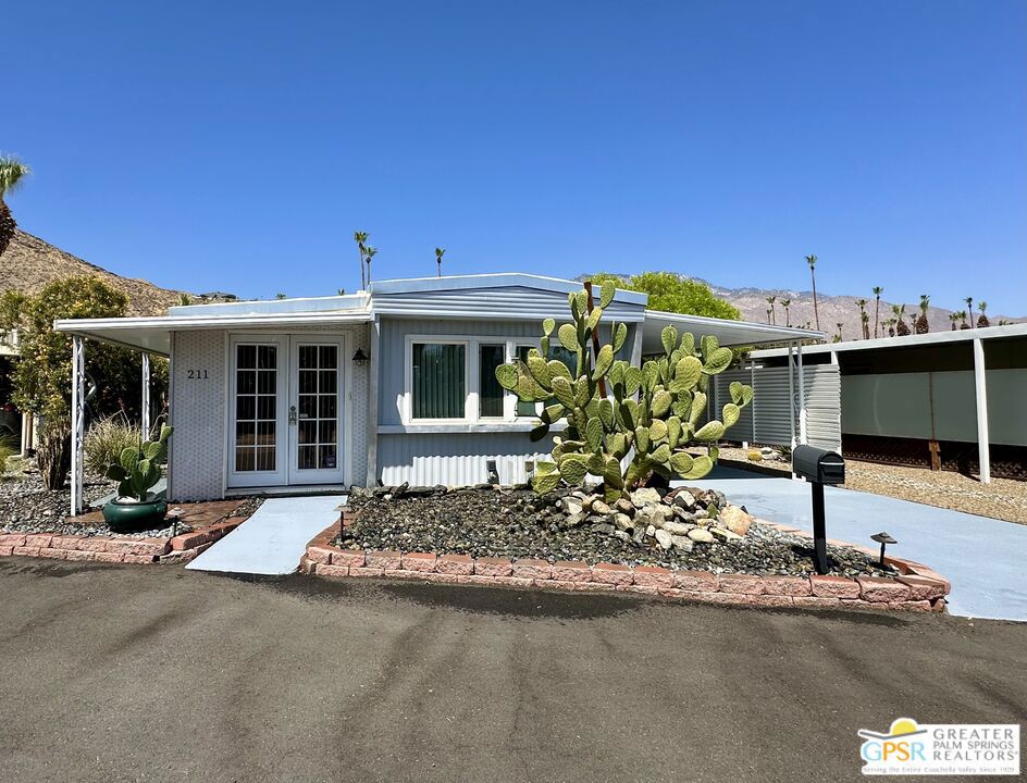 MUST SEE THIS PROPERTY IN PERSON. THE PHOTOS DON'T DO IT JUSTICE! Forget everything that comes to mind when you think "mobile home park." This beautifully renovated, fully furnished, and truly turnkey two-bedroom, one-bath mobile home is located on a premium lot just inside Safari Mobile Park, a vibrant 55+ community in the heart of Palm Springs. No need to drive deep into the property, this location offers both convenience and privacy, with a serene tree-lined view of lush oleanders instead of rows of other units. Inside, you'll find rich hardwood floors and a modern kitchen with sleek quartz countertops and stainless steel appliances. The primary bedroom has a cozy sitting area, ideal for morning coffee or enjoying a good movie. The enclosed utility room provides valuable bonus space, featuring a washer, dryer, and ample storage. And with the roof redone in 2023, major updates are already checked off the list. But the real showstopper? The landscaped backyard is a true outdoor retreat designed for lounging and dining in style. It comes fully furnished and is lined with a lush wall of mature ficus trees, offering privacy, greenery, and that Palm Springs indoor-outdoor lifestyle you've been dreaming of. A two-car carport adds convenience, and the community amenities complement it all. Enjoy a beautiful pool and spa, clubhouse, and the bonus of a grocery store just around the corner. Whether you're looking for a chic full-time residence or the perfect desert getaway, this one delivers far more than you'd expect, and it's ready for you now.
