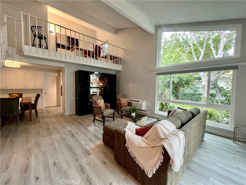 Renovated Seville 2 Model -- Live your best life in this fresh, spacious condo located in the renowned 55+ active adult community of Laguna Woods. Featuring luxury vinyl plank flooring and newer carpet, new windows & window shades, fresh paint and new lighting and mini split A/C & heat downstairs, you will appreciate this home for being clean, efficient, allergy-free and having less trip hazards. On the first level, enjoy living room with vaulted ceiling, tons of windows that let in plenty of natural light and a private enclosed patio with lemon tree. Main
level bedroom and bathroom has new shower doors and fixtures. Kitchen includes newer electric cook top, dishwasher, refrigerator, and
new Formica counter tops. Upstairs there is a loft set up as an office space overlooking the living room. Primary suite has a private balcony, en
suite bathroom and wardrobe mirrored closets. There is ample storage throughout, plus additional store locker in carport. Laundry room is just a
few steps away from the unit. The community offers a variety of amenities, including golf, pickleball, fitness center, swimming pools, library, 7
clubhouses, and over 250 social clubs. Convenient to dining, shops and medical services, Laguna Woods is a great place to call home. The
community is known for its beautiful scenery and landscape, its friendly residents, and its active lifestyle. You'll love living here!