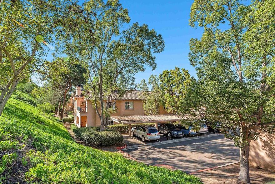 DISCOVER THE BEAUTY BEHIND THE GATES OF VISTA DEL LAGO! One of the best locations-secluded, backing to green space with Battle Mountain views, GARAGE, AND PLENTY OF OPEN PARKING, no adjacent building, south facing living room windows coupled with high ceilings the home is drenched with natural light. This popular open floor plan includes a cozy fireplace, Dual primary suites-walk in closet, upgraded countertops and remodeled walk in shower. One wall of secondary suite has a built in library with a remote controlled bed that comes out of the large lower drawer. Remodeled kitchen with granite countertops and stainless steel appliances including newer 2024 dishwasher.  Newer laminate wood tone flooring throughout. Full Size hall closet holds a  side by side washer/dryer with cabinets. Spacious covered patio to enjoy the views including a large storage closet. This lower unit has a convenient LARGE garage which provides room for a car and plenty of storage located steps from the patio for easy access for coming and going. Enjoy the multi million dollar premiere recreation facility including 2 pools (one a heated lap), 2 spas, 4 lighted tennis courts - pickleball, exercise room, changing rooms, billiard room, banquet room and more. In addition, Morada residents enjoy their own pool/spa and EV CHARGING station.  Part of the distinguished Poway Unified School District, Vista Del Lago is located near the Lake Hodges hiking trails and very close to the San Pasqual vineyards and Westfield's shopping center.