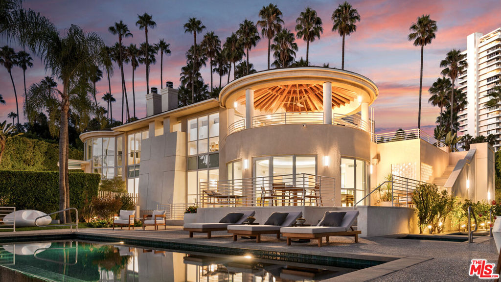 First time on the market since built by engineer for his own family! Beautifully sited on a quiet cul-de-sac north of Sunset in prime Beverly Hills, this gated contemporary masterpiece drawing inspiration from master architect Richard Meier and the iconic Hotel del Coronado, offers approximately 9,525 square feet of refined architectural living (including car lover's garage/lounge and bonus spaces/ approx. 1,700 sq ft. of viewing decks). Recently reimagined renovation, the residence blends modern architecture with timeless craftsmanship, designed for the ultimate indoor/outdoor California lifestyle.  A dramatic glass and stone entry with sweeping spiral staircase sets the tone, while soaring ceilings and expansive windows frame unobstructed views stretching from Downtown to Palos Verdes without a lengthy hilltop drive. Natural stone finishes, a full-service elevator, custom cabinetry, and abundant natural light create a warm yet sophisticated backdrop throughout. The private first floor primary suite is a sanctuary, complete with two full spa-like bathroom suites featuring a cedar sauna, Jacuzzi, walk-in stone shower, and oversized dual dressing rooms with bar sink and refrigerator. This hotel-like primary was designed with low decks overlooking the pool and immediate access for a morning swim. Two additional en suite bedrooms on the first floor are perfect for guests or dual offices.  Staff room on main floor designed with immediate access to the kitchen and entertaining areas while maintaining privacy for the primary main floor wing. On the upper floor at the heart of the home, a gourmet chef's kitchen boasts a Viking range, dual Sub-Zero refrigerators, wine storage, and a large bright breakfast room opening to an outdoor living room. Formal and informal dining spaces flow seamlessly to a covered outdoor terrace, perfect for entertaining with views of Century City and Downtown. The lower level is dedicated to entertainment with a full-floor recreation space which could be used for a gym, media lounge, pool table, secondary kitchen, full bath and private entry, ideal for guests or multi-generational living. A 500+ bottle wine cellar, wet bar, and multiple fireplaces enhance the lifestyle. Outside, lush landscaped grounds unfold around a dark-bottom infinity pool, dual spas (one a walk-in perfect for a cold plunge), sport court, rose garden, and citrus orchard. Mature palms, expansive lawns, and dramatic nighttime lighting complete the resort-like setting. Additional highlights include a dumb waiter servicing all levels, 5-zone HVAC, central vacuum, security system, commercial backup generator, and an 5-car collector's garage with additional motor court parking.