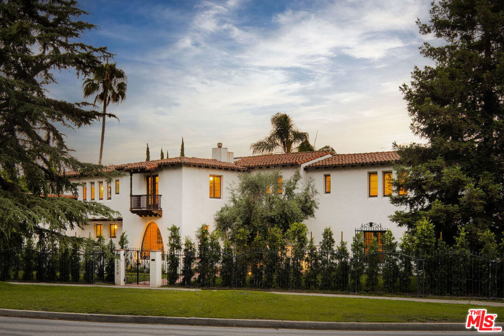 Presenting The Clifford Clinton Residence, HCM 997 in Los Feliz. Designed by architect Arthur W. Larson in 1928, this was once home to the family of Clifford Clinton, founder of the famous Clifton's Cafeteria. This formidable Spanish Colonial Revival is replete with impressive architectural detailing indicative of a bygone era, when flower fields and orange groves dotted the hills below the Observatory. Beyond the hedged and gated wraparound frontage spanning 230', Juliette balconies, decorative ironwork, tiled courtyards and patios, and red clay rooflines demonstrate the richness of period architecture rarely found. Romance unfolds inside, past the magnesite entry and foyer, through a deep arched threshold is the formal living room anchored by a grand fireplace, beautifully intact stained glass, and coffered ceilings, with French doors opening to a large tiled veranda. The dining room boasts impressive stained glass picture window, and opens to a front courtyard. Rare robin's egg blue original tile, wooden countertops, and lighting fixtures are found in the butler's pantry and kitchen tucked next to a sunny breakfast room. A stately office with hand stenciled ceilings, paneling, and fireplace is privately situated off the grand staircase. The second level floor plan features four large bedroom suites showcasing original colorful tiled bathrooms and 'wedding cake' ornamental plaster, plus sunroom and balconies with views of the city set among swaying palm trees. On the lower level, unwind and host movie nights in the screening room with plush seating for six. In 1936, Clinton commissioned the addition of a pool, sun deck, and bath house, where neighborhood kids could be found swimming all summer alongside his three children. Today, the tiled deco pool area remains a sunny gathering place; nearby a grassy knoll and dining pavilion provide a shady respite from the main entertaining space. Through a discrete gated driveway, the motor court and 3 car garage offer plenty of parking. For the past decade, the home has been restored and cared for by its current owners, with Mills Act tax credits available. This legacy estate's period details give this residence a deep sense of place and history, whereas the remarkably large scale of most all rooms lends an ease to modern living; this is a property you must see in person to appreciate!