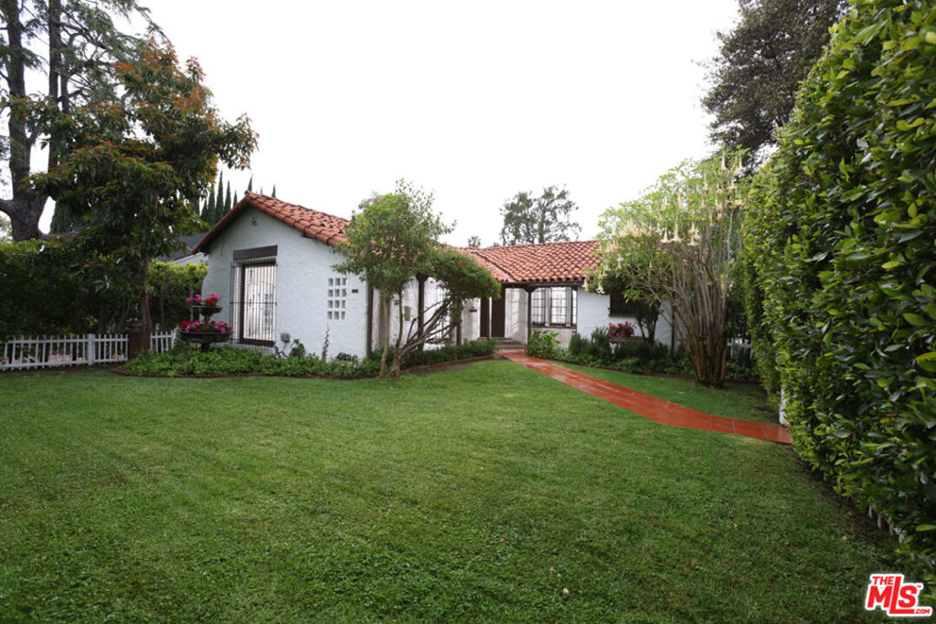 This charming Spanish home with authentic details has just been modernized. Just completed major upgrading including new kitchen cabinets and countertops, fresh paint inside and out, new roof. The home is surrounded by mature Landscaping and situated on a bright corner lot. The home features a spacious formal living room with high ceilings, dining room, stone fireplace and gorgeous chandeliers. Three bedrooms with two bathrooms, bonus breakfast room. Newer flooring in bathrooms and kitchen. Beautiful hardwood floors throughout the living areas. Excellent for entertaining. Private front and back yard, large indoor patio area, most appliances new. Walking distance from world famous Melrose with some of LA's best restaurants and shopping.