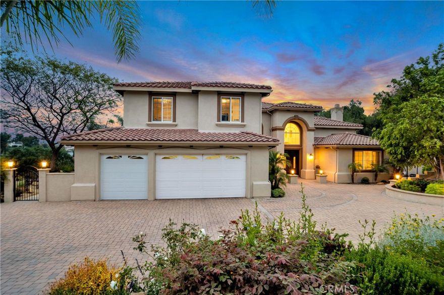 Exquisite 5 bed, 4.5 bath, 4,643 sq ft estate on over an acre of land with stupendous views in private, gated, enclave in Chatsworth. High ceilings, recessed lighting, & elegant finishes throughout! Grand, 2-story, formal entryway with lovely tile floors runs the length of the home. Entry to formal living room is a large archway flanked by 2 decorative pillars & offers vaulted ceiling, 2-story windows, hardwood floors, & archways on either side that lead to an additional living area one way & the formal dining room on the other, both with decorative crown molding & recessed ceilings. Off the dining room is a staircase with a private entrance up to a bonus room with hardwood floors, vaulted ceilings, & could be used as a guest apartment, home office, library, studio, or more. The enormous kitchen is a chef’s dream with a Sub-zero fridge, Wolf 6-burner range with griddle & double oven, marble counters, glass tile backsplash, granite topped center island with prep sink & breakfast bar seating. The sunny, breakfast nook is surrounded by windows & glass slider on 3 sides, offering appealing views overlooking the yard & the valley beyond. The adjacent family room offers a 2nd, cozy, fireplace, & stylish tile rug inlaid on the floor. 1 downstairs bedroom has hardwood floors, crown molding, walk-in closet, & en-suite ¾ bath with direct access to the pool area, ideal as guest accommodations. The elegant staircase leads to the remaining 4 bedrooms, including a wonderful primary suite, boasting double door entry, hardwood floors, fireplace, built-ins, an enormous walk-in closet, & sweeping views to enjoy. The en-suite spa-like bath offers a soaking tub, separate shower, dual vanities, & dressing area. Three additional bedrooms feature hardwood floors, mirrored closets, plantation shutters, & newer windows, 2 sharing a beautifully updated hall bath with quartz counters & tile shower, & 1 with its own ensuite bath. Additional features include 2-zone AC, water softening & filtration system, convenient guest powder bath, dedicated laundry room with utility sink, & direct access to the attached 3-car garage. Outside is a beautiful, Versailles pattern, stone patio, outdoor kitchen, sparkling pool, mature, drought conscious landscaping, & additional seating areas, all situated to best enjoy to panoramic views over the valley & hills beyond. Well situated near shopping, dining, entertainment, recreation, & major transportation thoroughfares. Don’t let this one pass you by.