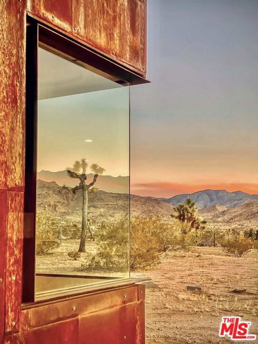 First time on the market: the prestigious Rotohouse, in the exclusive Monument Manor neighborhood of Joshua Tree, California. This organic architectural treasure is just a mile to the entrance of the popular Joshua Tree National Park, sitting between two large mounds of boulders enhanced by spectacular sunset vistas. House designed by world-class architect Michael Rotondi in 2007 and renovated over the course of 10 years.  The main entrance is through a custom glass door entering a fun open-air atrium. The sophisticated floorplan incorporates 2 stories 1,845 sq feet, with 10ft. ceiling in the upstairs bedroom and 14ft. high opening on downstairs bedroom, three bathrooms, two in the master suite, his and hers.  Characterized by simple forms and open volumes, the main addition is a cube 25 feet on each side. Adjacent to that is a long, narrow storage building with a roof deck pointing to a phenomenal spectacle of heaped rocks and sexy Pinto Mountains. Raw and handcrafted, the rugged exterior wrapped in corten steel set the trend for hi-desert buildings. Mondo central air eases extreme desert climate offering perfect comfort throughout.  Every custom window frames extraordinary and enchanting wild desert scenery. The included adjoining 2.5 acre parcel is priceless on it's own. It offers the perfect location for a potential second epic dwelling; perhaps on piers, so as to offer infinite vistas east and west. With this purchase you are not just buying a house but the true character that inspires the Joshua Tree nature and lifestyle.
