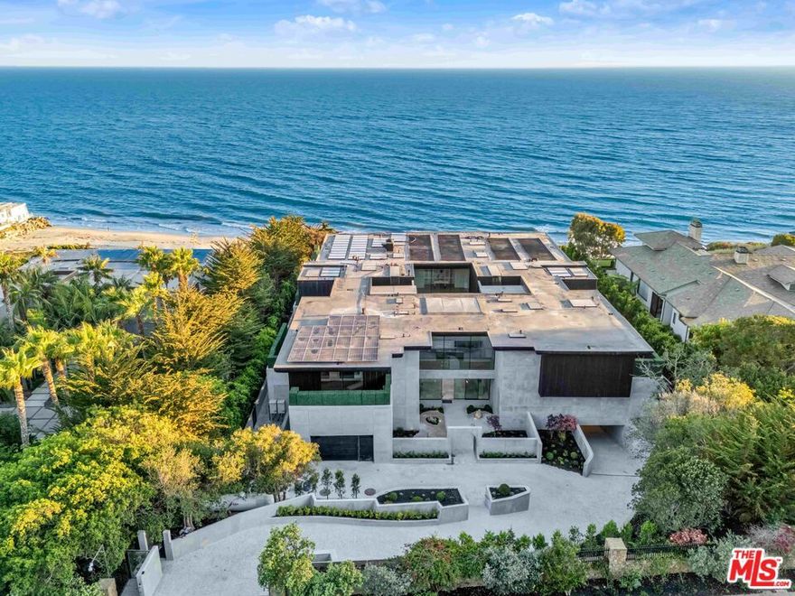 Simka Malibu is a residence conceived with permanence at its core. Rising from the bluffs above the Pacific Ocean, this awe-inspiring architectural work by renowned architect Kris Halliday, often referred to as "God's Architect," encompasses apx. 30,000 sq.ft. of meticulously engineered living space. Both fortress and refuge, the estate was deliberately sited and constructed with extraordinary foresight, designed to withstand fire, seismic activity, tsunami, mudslide, and coastal erosion, reflecting a singular commitment to longevity, resilience, and architectural integrity. Constructed with more than 7,300 cubic yards of super-reinforced concrete, Simka Malibu is a singular architectural statement shaped by one vision and one guiding hand. Its commanding lines of concrete and glass are balanced by sculptural landscaping and rare natural stone sourced from around the world, embodying Halliday's concept of "Brutality Vitality," where strength and serenity coexist in refined harmony. Concrete is elevated from raw material to an almost tactile softness, lending the home a sense of calm power. Arrival is intentionally ceremonial, unfolding through a secondary gated entrance into a serene Zen courtyard and stone-lined pathway. Inside, floor-to-ceiling walls of glass dissolve the boundary between interior and horizon, framing uninterrupted ocean views. The home is conceived as a sanctuary, a place designed to protect, restore, and inspire. Life at Simka Malibu is defined by a series of immersive experiences. A 176 foot, multi-level, vein-matched stone pool features a swim-up bar, sunken lounge, and dramatic viewing window that visually merges with the Pacific beyond. A state-of-the-art theater rivals the world's finest private cinemas, offering a 235-inch LED screen, Dolby Atmos sound, and bespoke Italian leather seating. A tranquil Japanese tea room provides a rare space for reflection and stillness. Entertaining is effortlessly supported by a full commercial-grade kitchen capable of serving up to 200 guests, alongside expansive terraces, shaded loggias, and a fully equipped outdoor kitchen. Throughout the grounds, water and nature are seamlessly integrated through Japanese gardens, koi ponds, waterfalls, meditation courts, and meandering pathways that invite quiet contemplation. Swinging daybeds, a circular fire lounge, and open-air courtyards transform leisure into ritual. Wellness is central to the estate's design, with a private spa offering a cold plunge, sauna, treatment rooms, and a state-of-the-art fitness center accented by underwater pool windows. A private nightclub, guest suites, and an underground garage accommodating up to ten vehicles complete the lifestyle amenities. The apx. 1,800 sq.ft. primary suite floats above the ocean, serving as a deeply private retreat with its own hot tubs, fireplace lounge, and spa-inspired bath. Additional suites mirror this sense of intimacy, combining organic materials, curated furnishings, and sweeping ocean panoramas. Even the marble-clad powder rooms are conceived as sculptural works of art, underscoring the estate's uncompromising attention to detail. With 10 bedrooms, 20 bathrooms, and seamless indoor-outdoor living, Simka Malibu achieves a rare balance of monumentality and warmth. It is not a home created for a decade or a generation, but for centuries. Simka Malibu stands as a timeless expression of architecture, conceived for eternity.