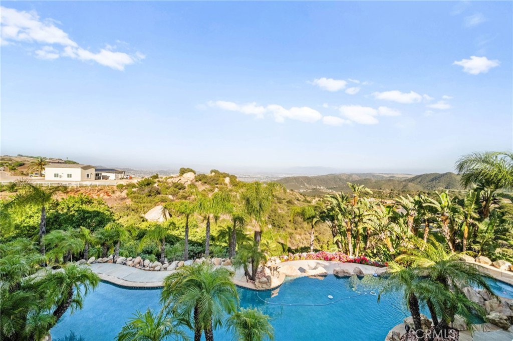 Exquisite Custom Estate with Panoramic Views in Prestigious La Cresta. Discover one of the most extraordinary homes currently available in Murrieta, offering over 6,400 sq ft of refined luxury on more than 5 acres, nestled in the highly coveted La Cresta community. Boasting 4 spacious bedrooms and 4.5 bathrooms, this exceptional property delivers the perfect blend of elegance, comfort, and functionality. Enter through a private, gated driveway to a grand double-door entrance, where you're welcomed by soaring ceilings and a dramatic foyer with rich finishes. The open-concept layout is designed to highlight the sweeping 180-degree views of the Murrieta and Temecula Valleys, visible from nearly every room in the home. Walls of windows and glass doors seamlessly connect the indoor living space to the stunning backyard oasis. Step outside to experience true resort-style living with a sparkling pool and spa, built-in custom BBQ island, and a private guest cabana complete with its own bathroom and shower, ideal for hosting or extended stays. Entertain, relax, and soak in all this property offers. The gourmet chef’s kitchen is a culinary masterpiece, complete with high-end stainless steel appliances, granite countertops, custom cabinetry, a large center island with seating, and walk-in pantry. Entertain with ease in the formal living and dining rooms, breakfast nook, and expansive family room, all showcasing incredible views. A fully-equipped custom bar, complete with sink and mini fridge, anchors the impressive game room featuring a billiards table, shuffleboard, and a temperature-controlled wine cellar. Downstairs includes two private ensuite bedrooms, one is currently utilized as a home office with a separate entrance. Upstairs, two additional ensuite bedrooms with walk-in closets. The luxurious primary suite is a true retreat- enjoy sunrises from your private balcony, unwind in the jetted tub, sauna, or massive walk-in shower, and enjoy the expansive walk-in closet with built-in cabinetry and an adjacent private gym. Additional features include an attached 4-car garage with built-in storage, central vacuum system, water softener, security system with cameras, and a solar power system. Set within one of Murrieta’s most sought-after communities, this property offers tranquility, privacy, and easy access to top-rated schools, shopping, dining, and the renowned Temecula wine country. This one-of-a-kind estate is a rare opportunity-schedule your private tour today!