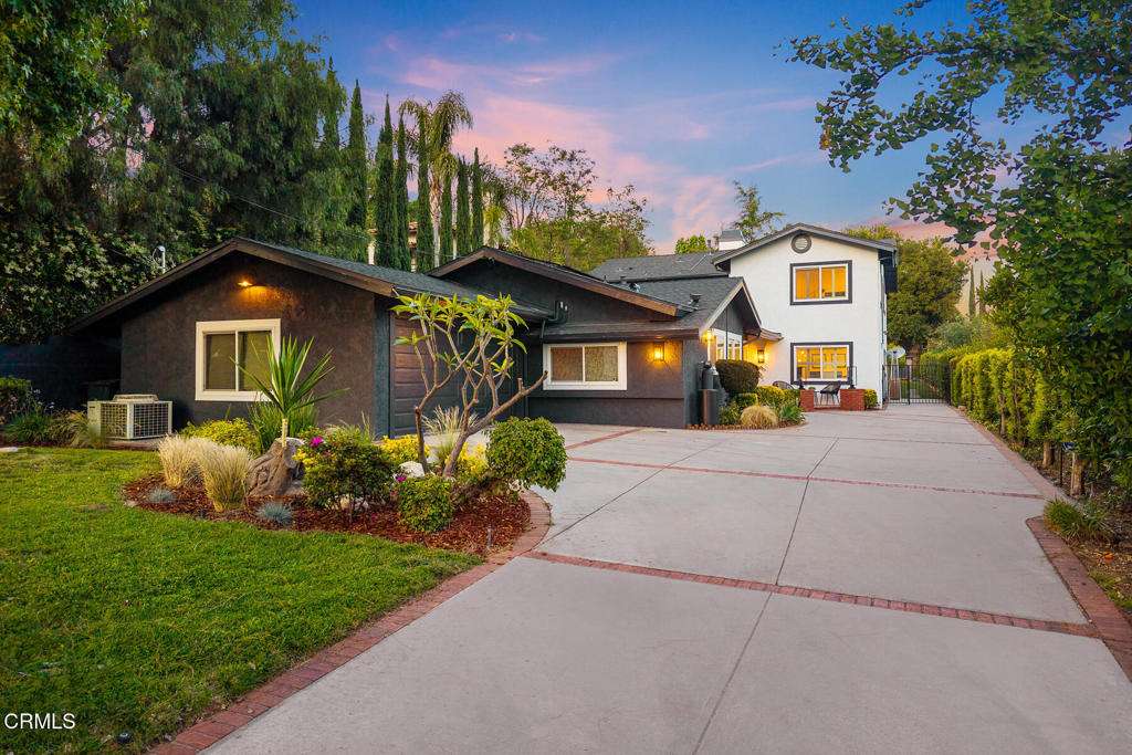 Delightfully set above Foothill Blvd. on an expansive 17,130 SF Lot, this west-facing two-story home sits well off of the street with an attached garage and ample space for parking. The home is highlighted with a functional floor plan, open living spaces and modern finishes. A brick porch welcomes you into a foyer with high ceilings and comfortable sitting area. Ahead, a flex space offers the perfect setting for a home office, gym or media room. The bright and open kitchen features stainless steel appliances, subway tile backsplash and center island with seating. A formal dining room with vaulted ceiling rests just beyond. Down a hall from the kitchen, a guest bedroom is thoughtfully appointed with a full bath. A laundry room and garage access are located off of the kitchen for ease of use. An expansive living room sits to the back of the first floor and is ready for entertainment with a wet bar, fireplace and access to a guest bathroom and back yard. An additional guest suite with full bath and enclosed porch is located down the hall. A guest bedroom rests to the side, completing the first floor. A wide stairwell leads to the second floor with a fourth guest bedroom serviced by a full bath off the hallway. Double doors lead to a primary suite with vaulted ceiling, fireplace and patio overlooking the backyard. The space is refined with double closets that lead to an ample sized full bathroom with double sinks, vanity, glass surround shower and separate soaking tub. Outside, a resort setting awaits. A raised deck with pergola presents the perfect space for outdoor entertaining and dining. Open for play, a four-hole putting and chipping green with berms and sand pits emulates the 12th hole at Augusta National Golf Club. Enjoy La Canada Flintridge living in this stylish home while being close to top rated schools, the YMCA, highways and town.