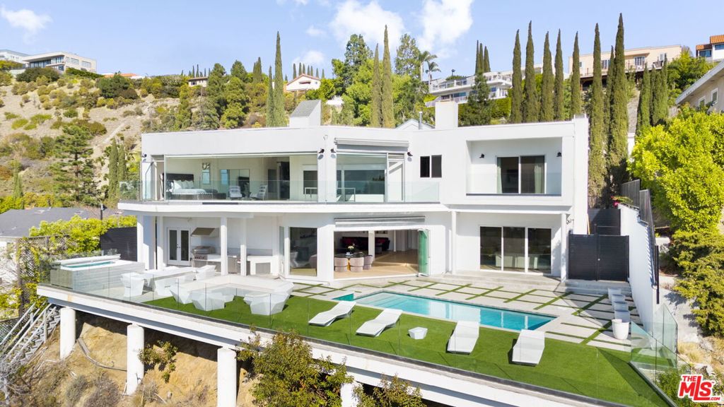 A stunning contemporary, perched atop the city with panoramic views to the ocean. Quietly sited in Mt. Olympus, but only a moment from the Sunset strip and all the city has to offer. Public rooms on the ground level that open out to the pool with western exposure that baths the house in light throughout the day and offers unmatched sunsets. A primary suite with a wall of windows that frame the Hollywood Hills and the city below, and an ensuite bathroom with 2 walk in closets, a steam shower and soaking tub. In total 3 ensuite bedrooms upstairs, and a 4th bedroom/office on the ground level. Perfect for entertaining; easy access and the rarity of ample parking in hills - all located in the heart of the city. This is consummate Indoor-outdoor living at its finest - privacy and proximity - the best of life in LA.