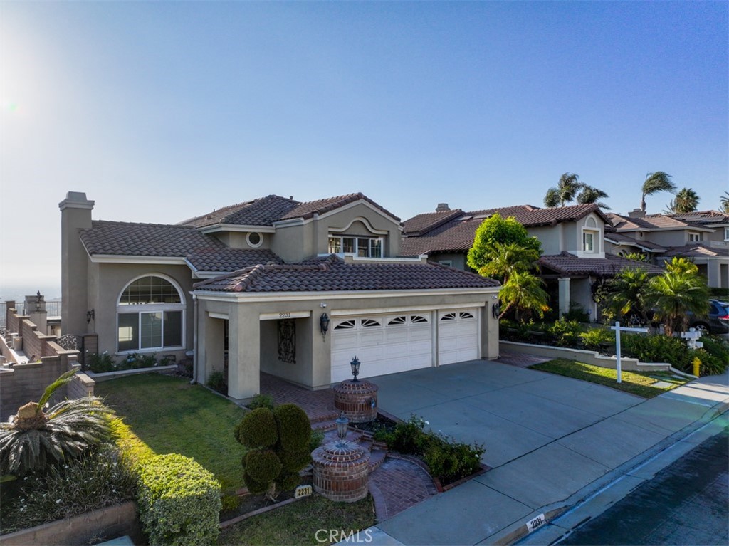 Luxury Living with Panoramic Views in Rancho Via Verde/Belmonte. These Pacer built homes rarely come on the market.
Welcome to 2231 Calle Margarita, a renovated 4-bedroom, 3-bathroom, 3-car garage residence with 2,590 sq. ft. of designer living space. Nestled in the prestigious Rancho Via Verde community of San Dimas, this home blends elegance, modern design, and resort-style amenities with smart, energy-efficient upgrades.The entryway opens to a living room with soaring vaulted ceilings and a cozy fireplace, setting the stage for a bright, inviting floor plan filled with natural light from skylights and expansive windows. The gourmet kitchen showcases white quartz counters, bold black cabinetry, professional-grade appliances, pendant lighting, and a pantry with pull-out shelving. A breakfast nook and formal dining room with scenic views make entertaining seamless. The adjacent family room features a custom fireplace, recessed lighting, and built-in surround sound, ideal for movie nights or gatherings.Upstairs, the home offers three bedrooms: the primary suite with a private balcony, custom built-out walk-in closet, and spa-inspired bathroom with skylights and a luxury shower with massaging jets; a secondary suite with its own balcony and full bath; and a middle bedroom connected via Jack-and-Jill layout. Downstairs, a bedroom and full bath, along with a dedicated laundry room, provide comfort and convenience for multi-generational living or guests.Step outside to your resort-style backyard retreat with a built-in 6-burner BBQ, stovetop, outdoor fridge, Jacuzzi, and fireplace, all framed by sweeping mountain and sunset views. Fruit trees and lush landscaping complete the California dream.Smart upgrades include whole-home carbon water filtration and softener, total home air filtration, dual-zone HVAC with WiFi thermostats, a tankless water heater, and double-paned windows. The exterior has been freshly repainted for modern curb appeal. The 3-car garage offers epoxy floors, cabinets, shelving, overhead storage, and dual EV chargers (one Tesla fast-charger ready). A built-in alarm system and video surveillance with DVR complete the upgrades.
Located minutes from Bonelli Regional Park, scenic trails, and top shopping and dining, this rare offering combines modern elegance, advanced technology, and resort-style living in one of San Dimas’ most desirable neighborhoods.