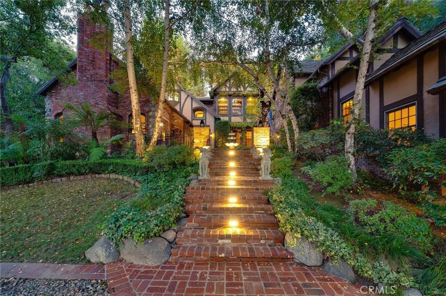 Nestled behind private gates on approximately two acres of beautifully manicured, park-like grounds, this stunning English Tudor estate offers 7,516 sq ft of timeless craftsmanship and refined elegance. From its classic timber-beamed and brick exterior, to its intricate interior woodwork, open vaulted ceilings with exposed wood beams, and stained and beveled glass windows, every detail reflects the character and grace of a bygone era—perfectly blended with modern luxury.  A grand formal entry welcomes you into a two-story foyer that opens to an expansive floor plan featuring a step-down living room with a dramatic floor-to-ceiling stone fireplace, a large formal dining room, and multiple gathering spaces ideal for entertaining. The gourmet kitchen is complemented by granite countertops with custom cabinets, island with prep sink, a butler’s pantry with wet bar, walk-in pantry, and premium appliances including Sub-Zero, Thermador, and KitchenAid. Unique spaces such as a charming potting room, large craft room, upstairs bonus/play room, separate office/library, and a game room with pool table add character and versatility.  There is truly plenty of space for everyone!

The home offers five spacious bedrooms, including an elegant primary suite with a cozy sitting area, fireplace, and access to an expansive balcony shared by most of the upstairs bedrooms. The luxurious en suite bathroom features a jetted soaking tub, separate tiled shower, double sinks with marble countertops, custom cabinetry, and a private vanity area—creating a serene retreat within the home.  Outdoors, enjoy resort-style living with a sparkling pool and spa, outdoor BBQ island, lighted pathways, and expansive lawns for entertaining or play. A long, gated circular driveway leads to two separate two-car garages with direct access to the home, and a spacious walk-in attic located above the garage provides additional storage or future potential.  Ideally located close to shopping, dining, entertainment, and freeways, and within an award-winning school district, this remarkable estate offers a rare combination of elegance, comfort, and privacy. A truly "one of a kind" property.