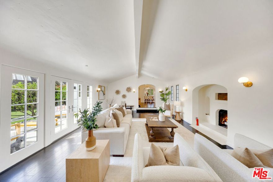 One of Miracle Mile's rare gated Spanish residences, privately set on a nearly 10,000 sq. ft. corner lot, blending historic artistry with modern comfort. This 3-bedroom, 3-bathroom home spans 2,503 sq. ft. and combines timeless character with thoughtful updates in one of Los Angeles' most desirable neighborhoods. The front yard offers classic curb appeal, while the backyard unfolds as a private retreat with shaded lounge areas and a sparkling 8-foot deep pool, ideal for entertaining or unwinding under the California sun. The entry is distinguished by Ernest A. Batchelder tiles at the front door, while the living room is anchored by a Batchelder fireplace surround that preserves rare architectural details from the period. Sunlight fills the expansive living room with hardwood floors, flowing seamlessly into the formal dining area and a bright kitchen with freshly painted cabinetry. French doors open onto a tiled terrace that flows seamlessly to the backyard, delivering the indoor-outdoor living experience Los Angeles buyers search for, your own private retreat that evokes a true California oasis. Recent improvements provide both beauty and peace of mind, including a re-tiled roof with new waterproof underlayment, sewer liner installation, two new bathroom vanities, fresh interior and exterior paint, new lighting in bedrooms, living room, and hallways, an upgraded security system, termite prevention and treatment completed, and maintenance updates to the pool and fireplace. Just minutes from The Grove, LACMA, Beverly Hills, and premier dining and shopping, this home offers the perfect balance of central convenience and private sanctuary living. Timeless design. Classic curb appeal. Private oasis. This is Miracle Mile living at its finest.