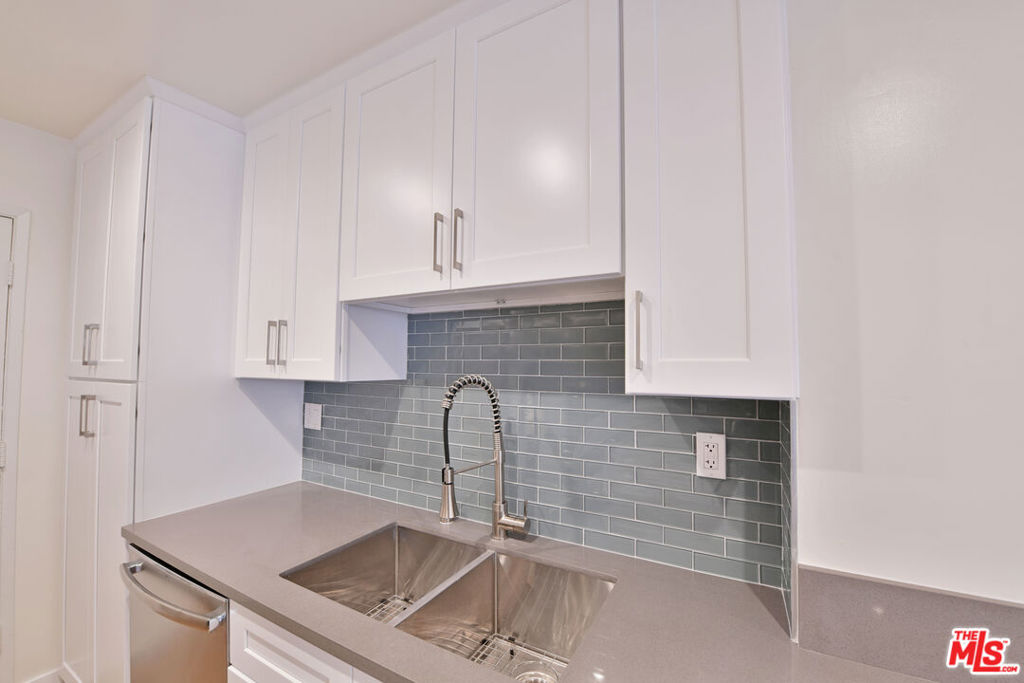 This modern 1 bedroom apartment features an open concept living area with wood style flooring, recessed lighting, and a beautifully updated kitchen with quartz countertops, sleek cabinetry, and a stylish glass tile backsplash. Large sliding doors lead to an oversized private patio, perfect for entertaining or relaxing outdoors. Freshly renovated and filled with natural light, this home offers a comfortable layout with contemporary finishes in a prime location.