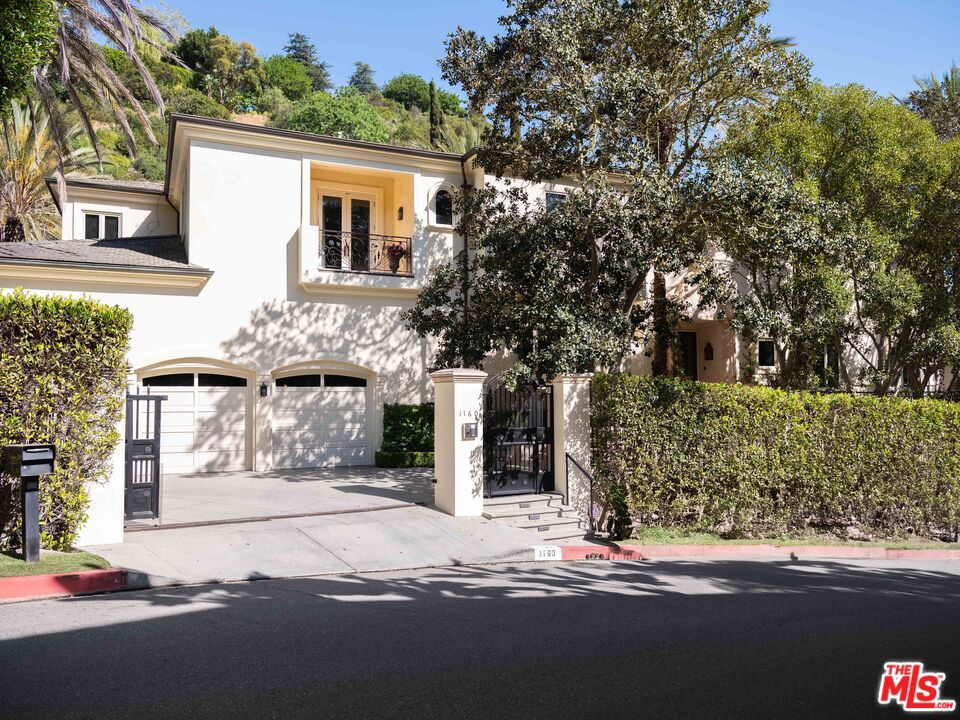 Set behind gates in prime Bel Air, this stunning custom Mediterranean estate blends timeless elegance with modern comfort. Grand in scale yet warm in design, the home offers formal and informal living spaces lined with French doors that open to lush, private grounds ideal for entertaining and everyday living. The main level features an elegant living room with fireplace, great room with wet bar, paneled library, maid's quarters, formal dining room, and a gourmet chef's kitchen with top-tier appliances. Upstairs includes a media room and four ensuite bedrooms, including a luxurious primary suite with sitting area, fireplace, showroom closets, and marble bath. The resort-like setting is surrounded by mature trees and includes manicured lawns, a large pool and spa, dining pergola with outdoor fireplace and dog run. Complete with Sonos sound and timeless detailing throughout, this estate offers privacy, scale, and enduring elegance in one of L.A.'s most coveted neighborhoods.