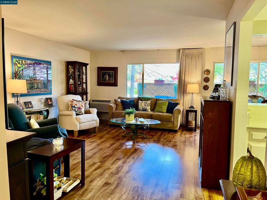 Charming Kentfield Home with Custom Updates and Serene Surroundings Nestled in a welcoming community with walkable access to a nearby park and majestic redwood trees, this beautifully updated Kentfield model offers the perfect blend of comfort, style, and convenience. The spacious floor plan is enhanced by luxury vinyl plank flooring throughout—durable, easy to maintain, and ideal for everyday living. The versatile living and dining "ell" area features custom built-in cabinetry with five deep storage compartments, a lift-out desk, and an integrated electrical charging station—perfect for work-from-home flexibility.  Cheery kitchen boasts sleek stone countertops, a smooth-top range, and thoughtfully designed pull-out shelves for maximum functionality. The bathroom is a true retreat, showcasing a large walk-in shower with rain glass doors and dual sidelites, a modern vessel sink atop a stone vanity, closeted Bosch washer/dryer. Additional highlights include Window shutters in the bedrooms for privacy and charm. Ground-level patio with lattice privacy screens for outdoor relaxation. Smooth ceilings and updated lighting for a fresh, contemporary feel. Keyless entry installed.