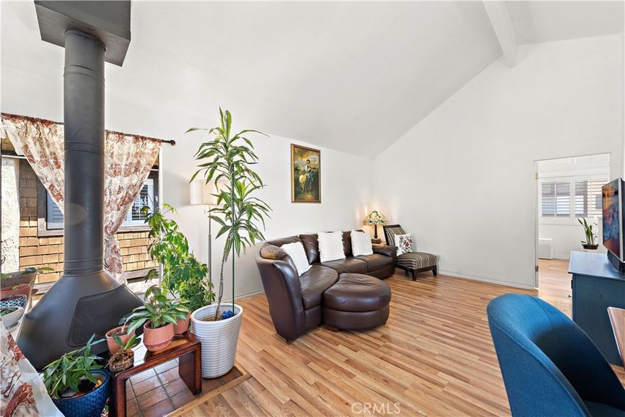 Welcome to your peaceful, updated 1-bedroom, 1-bath end unit condo nestled in a gated community. This end unit, with stairs leading exclusively to your door, shares only one common wall, providing added privacy. The upper-level home features soaring vaulted ceilings and bright rooms filled with natural light, complemented by plantation shutters throughout. Recently refreshed with new paint and flooring, the open kitchen has quartz countertops and additional cabinetry. The cozy living room with a fireplace overlooks a spacious patio, perfect for entertaining or relaxing, with a convenient washer and dryer area. The bedroom is illuminated by a skylight and includes a newly renovated vanity area along with a spacious walk-in closet. Residents enjoy access to two pools, two hot tubs, tennis courts, and beautifully maintained grounds. With easy access to shopping, dining, and freeways, this location offers exceptional convenience. Lakewood Shores provides a vibrant community lifestyle and is the perfect place to call home!