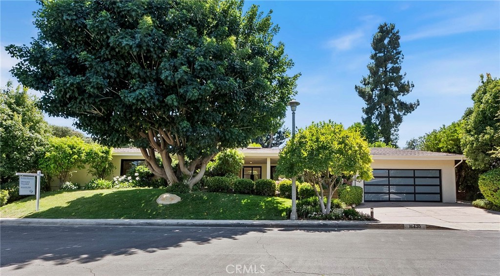 Welcome to Royal Oaks—one of Encino’s most prestigious and sought-after enclaves. Perfectly situated in the coveted Lanai Road School District, this stunning single-level modern mid-century estate offers the ultimate blend of privacy, location, and style—ideally nestled between the Westside and the Valley. As you approach the home, you’re greeted by a serene covered porch and a Zen-like fountain, setting the tone for what lies inside. Spanning over 3,550 square feet, this thoughtfully designed residence features 5 bedrooms and 6 bathrooms, all situated on an ultra-private, beautifully landscaped lot.
Inside, natural light floods the open floor plan through skylights, and the stylish mid-century character that defines the home. The chef’s kitchen is a true showstopper—featuring a massive quartz center island, top-of-the-line Wolf range, Sub-Zero refrigerator, full sized wine refrigerator, custom walk-in pantry with floating shelves, and sleek steel-and-glass sliding doors. The living room boasts a dramatic floor-to-ceiling fireplace with doors that open directly to the tranquil yard. The primary suite is a true luxury retreat, offering its own decorative fireplace, heated towel racks, remote-control toilets, dual walk-in closets, and two full en-suite bathrooms—yes, two! A private guest room with its own adjacent bath completes the home’s thoughtful layout. Step into your own personal resort in the backyard, complete with a sparkling pool, cascading waterfall, lush green lawn, and an oversized covered patio—designed for serious lounging and effortless entertaining. Fire up the grill in the outdoor kitchen, set the vibe, and enjoy the carefree lifestyle. Completely renovated with no expense spared, this home flawlessly pairs modern organic design with luxurious functionality—located in one of Encino’s most exclusive neighborhoods.