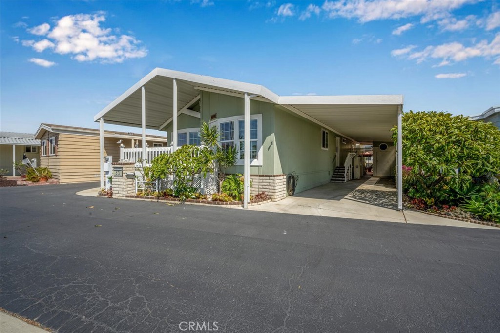 Location Location Location!!! This 55+ Community home is sitting pretty right in the middle of highly desirable Rancho del Rey. Situated right across from the Main Clubhouse making it VERY convenient for enjoying Park amenities such as heated swimming pool and spa, practice putting green right across the street, sauna, guest parking and much more. This 2004 Skyline built home offers a bright and open floorplan with a spacious kitchen that opens to the living room. Other interior features include dual pane windows that provide an amazing amount of natural light and relaxing views. This home is equipped with forced air heating and AC / cooling, tasteful laminate flooring in the kitchen, living room, office and hallway areas, 2 full bathrooms with the master bath offering dual sinks, cabinet storage space for extra towels and linens in addition to a separate soaking tub and shower with safety grab bars in the shower. The spacious master bedroom also offers a large walk-in closet. Rounding out the interior includes all stainless kitchen appliances which include refrigerator, dishwasher, built-in microwave, freestanding gas range and convection oven and last but not least front-loading washer and dryer combo. Exterior notables include a very relaxing and private front porch that overlooks the main clubhouse grounds, attached covered tandem carport that offers an electric wheelchair lift, guest parking right across the street, hard to find backyard area with covered canopy and storage shed. Rancho del Rey Mobile Estates is privately owned and is convenient to shopping, restaurants, freeways, hospitals, sandy beaches, paddle board or kayak in adjacent Huntington Harbour, wetland hiking trails, Main Street Huntington Beach and so much more. Arguably the BEST Value Park HB has to offer hands down.