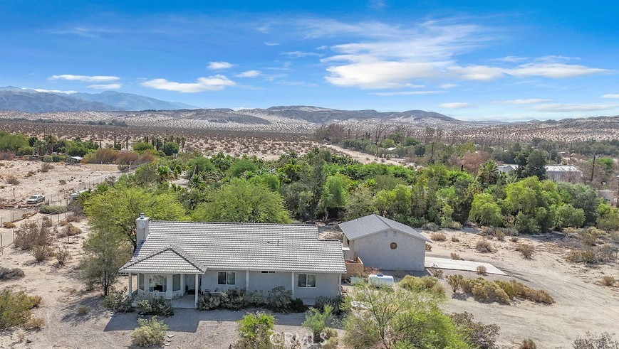 Welcome to 20980 Artesia Road—your private desert retreat on a combined 5 acres of serene, fully fenced land just 15 to 20 minutes from vibrant downtown Palm Springs. This beautifully maintained home sits on two separate 2.5-acre parcels, offering stunning unobstructed views of Mount San Jacinto and expansive desert landscape in every direction.
Inside, you'll find a bright, spacious interior with high ceilings, abundant natural light, and tile floors throughout. The open living room features large picture windows and a striking dark stone fireplace, perfect for cozy nights in. The kitchen is equipped with warm wood cabinetry, granite countertops, and a clean, functional layout for any home chef.
The primary suite includes an en suite bath with a large vanity, a walk-in shower with glass block accents, and a separate toilet area for added privacy. Additional rooms offer flexibility for bedrooms, office space, or hobby areas.
Outdoors, enjoy peaceful mornings or sunset views from the full-length covered patio. The property boasts 30 mature Majul date palms, native landscaping, and wide-open space ideal for stargazing, gardening, or even horses and livestock. There’s also an oversized detached 2-car garage that’s plumbed and includes an unfinished half bath—perfect for a future casita, workshop, or guest space conversion.
With two separate legal parcels, potential for short-term rental use, and endless space to expand or build, this property offers incredible flexibility and long-term value. Whether you’re looking for a full-time residence, vacation escape, or investment opportunity, this one delivers desert living at its finest—calm, quiet, and close to it all.