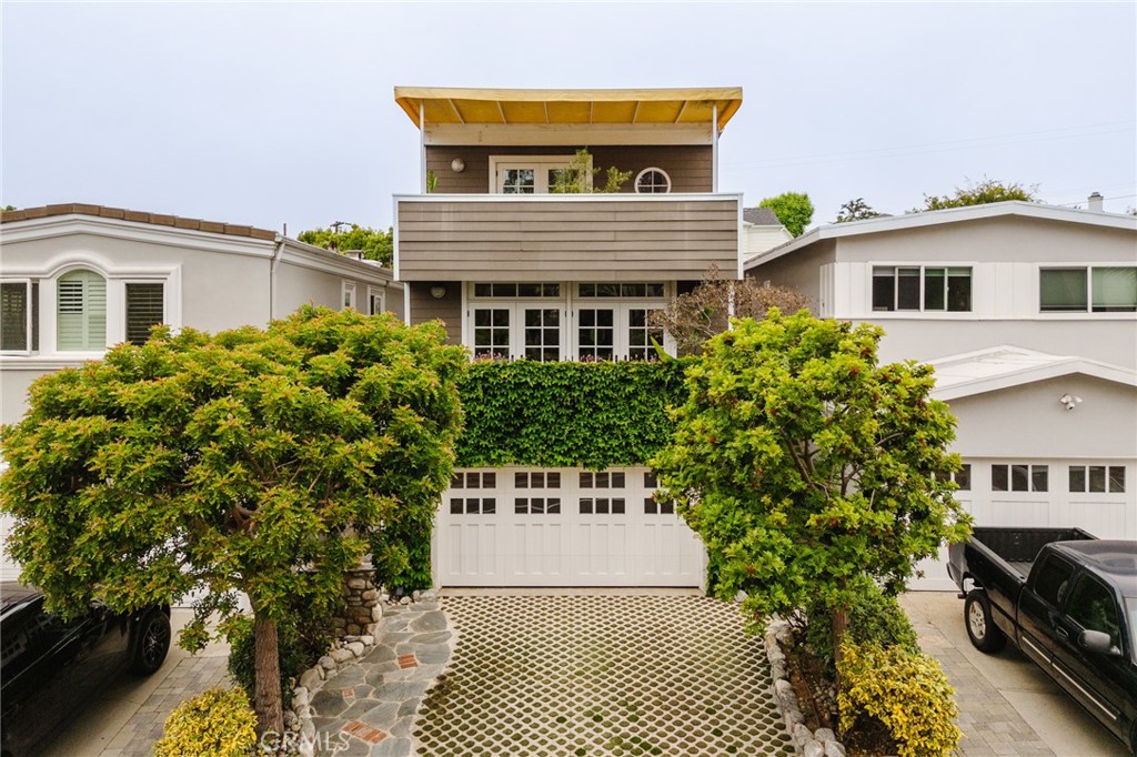 Stunning fully remodeled beach residence with impeccable design and a private backyard in the highly sought-after Manhattan Beach tree section. The home’s curb appeal captivates with refined architectural lines, lush climbing greenery, and mature sculpted trees framing the entry, while a custom stone-inlaid driveway and carriage-style garage door add timeless character. Unique indoor-outdoor living is highlighted by multiple balconies throughout the home bringing in abundant fresh ocean air, and a large bonus room with a full en-suite bathroom—perfect as an office or guest suite—opening to a stylish backyard complete with a stone fire pit, BBQ area, and ample seating, designed for effortless entertaining and memorable moments with friends and family.
The stairs lead you to French doors revealing a striking open-concept interior with elegant white paneling, exposed beams, classic double French doors that flood the room with natural light, hardwood floors and a modern chandelier amongst other minimalist pendants. The show-stopping brick fireplace provides both warmth and charm. The remodeled kitchen exudes bright, modern sophistication with crisp white cabinetry, glass-front cabinets, and a spacious wooden island with seating—ideal for cozy mornings. Enhanced with white marble countertops and abundant natural light, also features a spacious pantry with additional cabinetry, a water filtration system, and a concealed door, offering ample storage and a cohesive aesthetic.
Upstairs, three generously sized bedrooms each offer their own charm and functionality, along with a designated closet space with side-by-side washer and dryer for convenience. The primary suite is a sanctuary of comfort and design, featuring a large private balcony with awning, seating and serene views of the green belt and American Martyrs, ample custom closet space, and a luxurious en-suite bathroom with dual vanities and a separate glass-enclosed shower. Every detail has been thoughtfully curated to make this home truly feel like yours. Includes 8 solar panels and a Tesla wall battery that are all fully paid off.