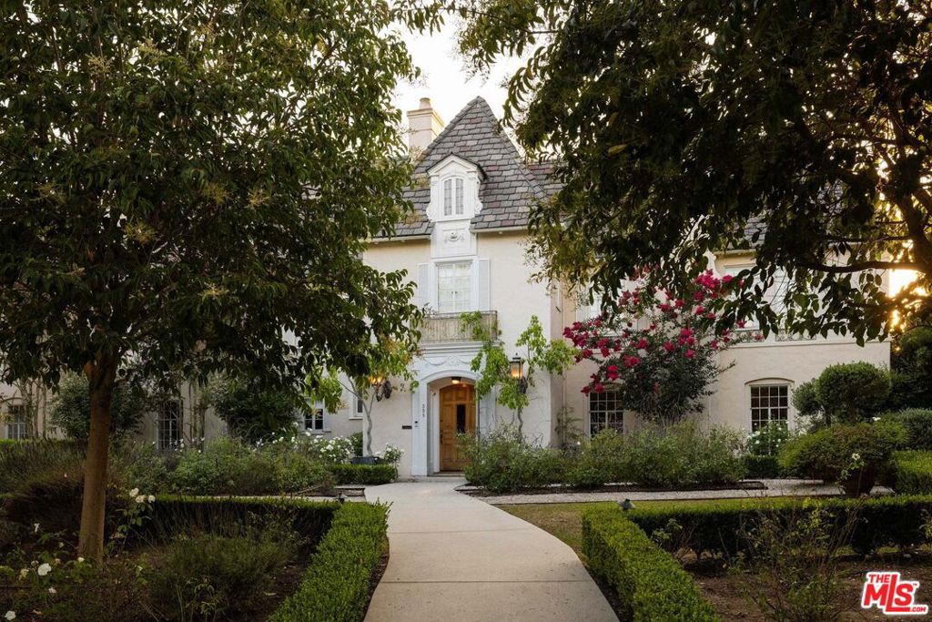 This one-of-a-kind, historic, designer-done chateau is an iconic estate located on one of the most desirable, tree-lined streets in Hancock Park. The trophy 6 bed 6.5 bath property sits on an expansive, wide, flat .75 acre lot. Tastefully re-imagined, this entertainer's paradise offers a premier living experience with modern amenities, while embracing the charm and authenticity of the original architecture. Enter through a dramatic double-height foyer, which leads to a perfectly-appointed formal living room with an attached sunroom/bar that opens to the yard and sparkling pool. A wood-paneled library, dining room, chef's kitchen, and outdoor dining areas are highlights of the main level. Upstairs, the primary suite is the ultimate escape with a cozy sitting room, gorgeous bathroom, and a balcony overlooking the gardens. Multiple en-suite bedrooms, as well as a charming attic, complete the upstairs. With its own private entrance, access the attached guest house, brightly lit and beautifully appointed. The ultimate outdoor experience includes a generous seating area with a fireplace, a vegetable garden, a citrus and olive grove, a reflection pool, a large swimming pool and spa and an inground trampoline. This is a rare opportunity to own one of the most beautiful homes in the neighborhood.