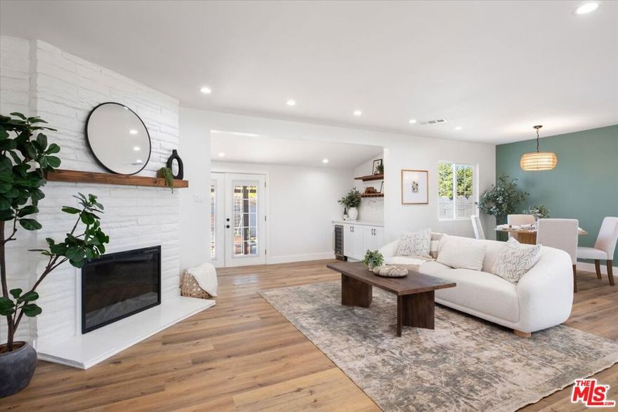 Welcome to this completely remodeled and renovated property that feels like home from the moment you walk in!  This beautiful residence features three spacious bedrooms and two brand-new bathrooms, including a stunning en-suite with a double vanity.  Enjoy a large open-concept living area with a brand-new kitchen, quartz countertops, stainless steel appliances, and a large pantry for extra storage. A separate laundry room with built-in cabinetry adds convenience and function.  An additional flexible living space provides room to relax, create, or gather. The bar area and custom built-in shelving make it perfect for entertaining or unwinding. A fireplace adds warmth and ambiance to the main living room. Step through the French doors to a spacious covered patio overlooking the newly landscaped backyard, featuring a variety of fruit trees.  Additional highlights include a brand-new roof, new electrical and plumbing throughout, fresh interior and exterior paint, and a two-car garage offering ample parking and storage.  Perfectly located near Valley Glen, this home offers a prime location and beautifully balanced design.  Every detail was crafted to create a space that is both timeless and inviting.