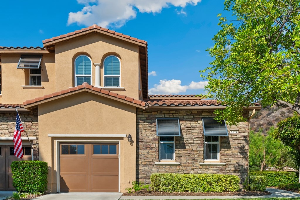 Gorgeous 2 bed, 2 bath condo located in the highly desirable 55+ gated community Trilogy at Glen Ivy! This stunning home is nestled up against the foothills, with no rear neighbors, offering fantastic panoramic views, with lots of seclusion and privacy - it is the most coveted lot in Cobblestone Canyon and this is one of the largest lot in the community! The interior is open and spacious with plantations shutters, recessed lights, tile and carpet floors. The formal rotunda entry opens to the spacious great room with fireplace, there is a slider to the backyard, a dining area, and the stunning kitchen features a large center island with granite counters, matching backsplash, and stainless steel appliances with brand new dishwasher and microwave. The bedrooms offer lots of privacy and sit on either side of the home. The large primary suite has a private bathroom with dual sink vanity, and full-size walk-in shower. There is also a bonus room that could be used as an office or work out area that sits between the entry and the secondary bedroom. A hall bathroom and an in-unit laundry room complete the floor plan. Enjoy the park-like backyard with covered patio, lush landscaping, with well kept grass and phenomenal foothill views - this is the perfect space for entertaining guests! This home also offers an attached 2-Car Tandem Garage, and resident's get to enjoy an array of Resort-like amenities including banquet facilities, club house, rec room, fitness center, golf course, pool, spa, pickleball and tennis courts, plus many community events. Schedule your private tour today and do not miss out on this gem!