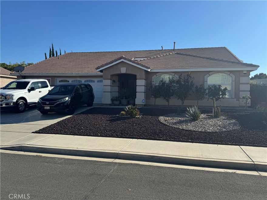 Stop the car! This home is a must see.  Located in Victorville is a spacious 4-bedroom, 2-bathroom, 3 car garage home situated on a corner lot.  As you drive up, you can't help but notice the low maintenance landscaping and the pride of ownership that is on display.  While walking up to this home you are greeted by a lovely front porch perfect for a morning cup of coffee.  Upon entering, you have your spacious dining room to your left which flows into your large formal living room.  The tall ceiling height and accent columns add to the grandeur of this home.  Proceed to your left and you will enter your spacious family room with a double-sided fireplace perfect for those cozy nights.  Your large kitchen with plenty of cabinet space and a dining area overlook your family room which is perfect for entertaining.  Walk to the west side of the home and you arrive at your indoor laundry room.  Continue and you will enter the large primary bedroom with an ensuite bathroom and spacious walk-in closet.  Down the hallway is your guest restroom and three large bedrooms with ceiling fans.  The backyard is ready for you to enjoy with a covered patio, low maintenance landscaping and small fruit trees.  This home won't last long.  Schedule your showing today.