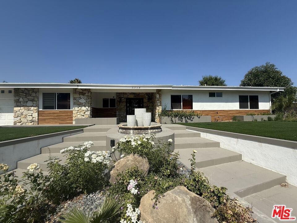 Step into sophistication in this beautifully appointed home, tucked away in a peaceful cul-de-sac within one of the area's most coveted school districts. Designed for comfort, style, and convenience, this property blends timeless elegance with modern upgrades perfect for those who expect more from where they live. From the moment you enter, soaring exposed beams and a dramatic double-sided fireplace set the tone for relaxed luxury. Rich hardwood floors flow seamlessly through the open living space, creating an inviting atmosphere for both entertaining and unwinding. At the heart of the home, the remodeled chef's kitchen boasts custom premium cabinetry, sleek finishes, and generous counter space ideal for everything from quick weekday meals to gourmet dinner parties.The spacious primary suite is a serene retreat, featuring a large walk-in closet, dedicated vanity area, and a spa-inspired bathroom with a walk-in shower. Two additional bedrooms share a stylish Jack-and-Jill bathroom, while an adaptable bonus room offers space for a home office, gym, or guest suite. Eco-conscious living comes easy with an EV charging hook-up and water-saving, low-maintenance turf landscaping. Large sliding doors open to your private backyard sanctuary complete with a shaded pergola, peaceful sitting areas, and sweeping city and valley views. Additional conveniences include a separate laundry room, ample storage, and a versatile layout that adapts to your lifestyle. Whether hosting friends, working from home, or enjoying quiet evenings outdoors, this residence delivers the elevated Southern California living experience you deserve.