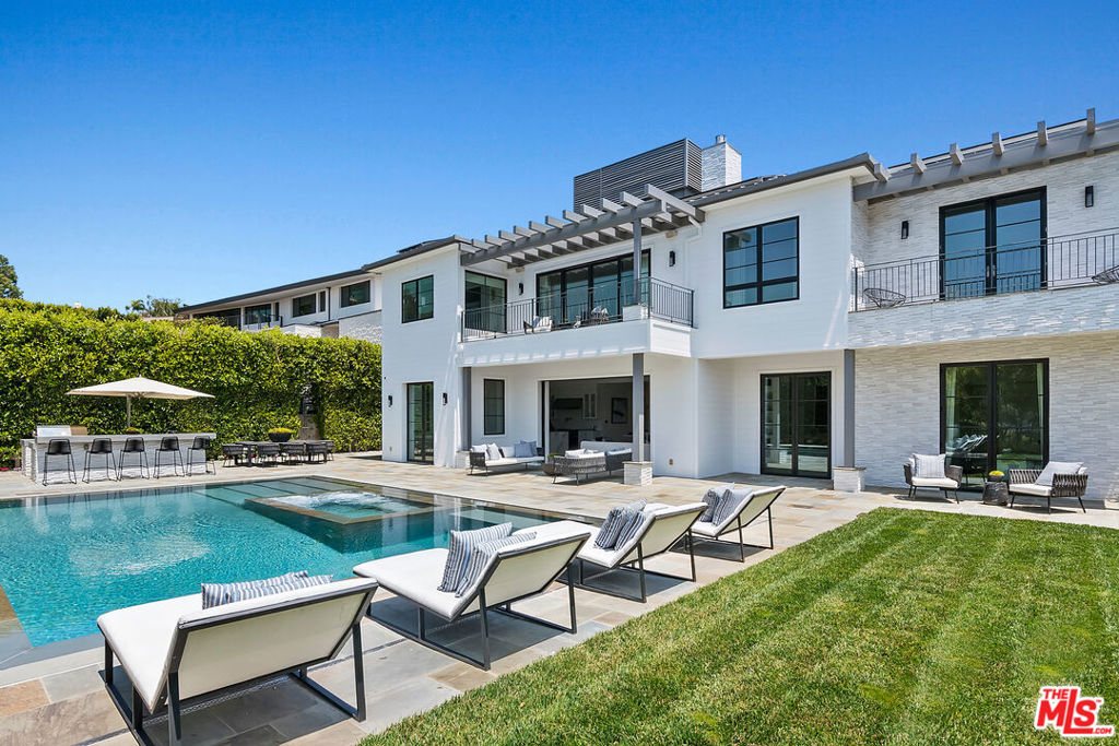 This meticulously crafted estate is located in the highly desirable Riviera of Pacific Palisades, which is known as one of Los Angeles's most sought-after neighborhoods. The house is designed in a grand Nantucket modern style and is surrounded by the beautiful Santa Monica Mountains, allowing for a sun-filled ocean breeze. As you enter the property through tempered glass and iron gates, you are greeted by the stunning 3D white marble exterior. Inside, European oak floors extend throughout the entire house, adding an elegant touch. The main level of the house offers a spacious living room with a fireplace, an open dining room, an office with a separate entrance from the front yard, a guest bedroom suite, Chef's kitchen with top-of-the-line appliances and features an oversized waterfall suede island that serves as a focal point. Slide open the La Cantina pocket doors, and you'll find yourself on the raw bluestone patio, where you can enjoy the zero-edge pool and soak in the serene ambiance. Additionally, there is a custom outdoor BBQ area and a Tuuci lounge canopy, creating a resort-like experience in your own backyard. Moving upstairs, the primary suite is the highlight of the home. It boasts a generous size, a sitting area, a fireplace, and a balcony overlooking the surroundings. The primary bathroom offers dual vanities, a spa shower adorned with lavish Italian Calacatta marble, and a luxurious dressing room. Each of the secondary and third bedrooms also features its own private patio, allowing for an ultimate indoor/outdoor lifestyle. The lower level of the house is designed for entertainment and includes an acoustic theater, a temperature-controlled wine cellar, a bar, a guest bedroom, and a patio area. This level is perfect for hosting gatherings and enjoying leisure activities. In total, this remarkable estate offers 5 bedrooms, 8 bathrooms, and a 6-car collector's garage. For convenience, an elevator connects all three floors, providing easy access to every part of the house. This exquisite property presents an opportunity to embark upon a new chapter of luxurious living, combining elegance, functionality, and the beauty of its natural surroundings.