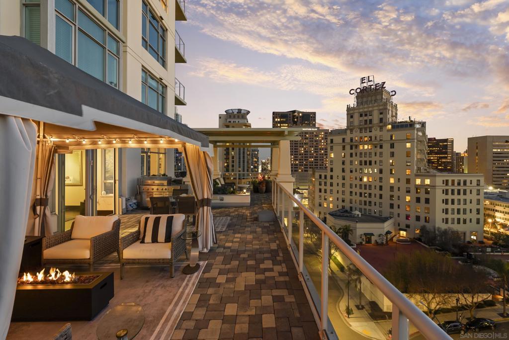 Experience year-round indoor-outdoor living in this rare luxury residence, highlighted by a spacious wraparound terrace with multiple seating areas, BBQ, firepit, cabana, garden, and sweeping views of the city, landmarks, parks, and mountains. Inside, no detail has been overlooked—custom Italian doors, bamboo espresso flooring, designer shades, art lighting, and two elegant fireplaces create a refined ambiance, enhanced by a Denon audio system. The versatile floor plan showcases a striking entry, an art gallery flex space with accordion doors to the terrace, formal living and dining rooms, a den/family room, and split bedrooms for privacy. Two primary suites boast spa-like baths and walk-in closets, with the main suite offering direct terrace access. The den features a wet bar, wine fridge, ice maker, and private balcony—perfect for entertaining. The modern kitchen impresses with stone counters, sleek cabinetry, Miele appliances, dual sinks, and an island with seating. Located in the prestigious Discovery building, enjoy concierge service, a rooftop pool, spa, gym, lounge, and BBQs. Nestled in tranquil Cortez Hill yet minutes from Little Italy, the Marina District, Gaslamp, and East Village, this home blends luxury, comfort, and an unbeatable location.