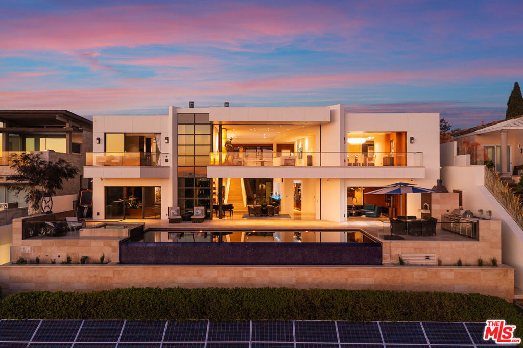 This estate boasts unparalleled design and unrivaled construction quality, with explosive front-row panoramic views of the harbor. Sitting on more than 1/3 of an acre, the 11,000+ sq. ft. home is one of the largest private residences in all of North America to be certified LEED Platinum and includes a $1m+ custom 14-seat theater/2 channel audiophile listening room designed by Keith Yates, a commercial full-size elevator by Kone, a full-size professional bar, full automation system by Savant, security cameras, a gym, 4-car garage, basement playroom that is readily convertible to a wine cellar, an infinity pool with Jacuzzi, outdoor entertainment area complete with grill, refrigerator, ice maker, and full-size wood-burning pizza oven, and much more. No expense was spared in the construction as it comprises 1 million pounds of heavy steel and 17,000 yards of concrete (no wood was used), solid bronze windows, 14,000 sq. ft. of Jerusalem stone, Venetian plaster, resting on caissons extending down 25 feet into bedrock. A 26.5KW solar array provides a large percentage of the home's energy requirements, a 100% water treatment process can re-process and recycle all the water needs for the home, a separate 38KW generator with a built-in fuel supply that can power the emergency functions of the house for several days. While the views are the best that Newport Beach has to offer, the home's quality, elegance, and technological sophistication are the best the world has to offer.